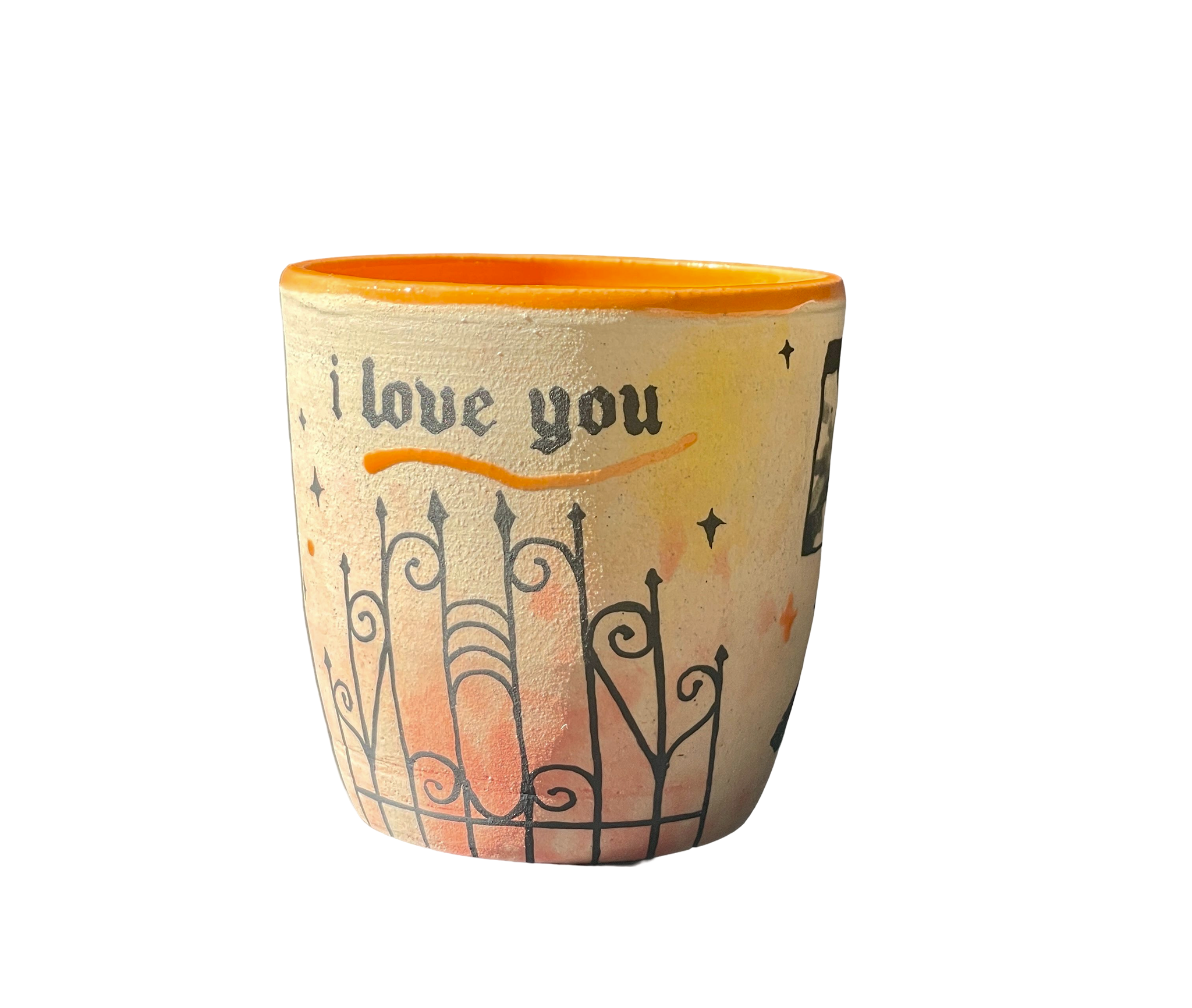 A decorative ceramic mug with blackletter text that says 'I love you' and a fence, other hand painted elements wrap around.