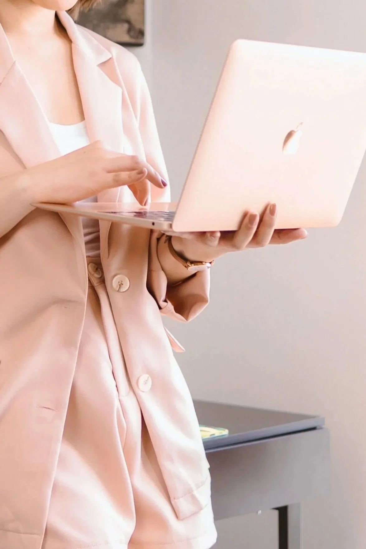 Person wearing pink working on a laptop.