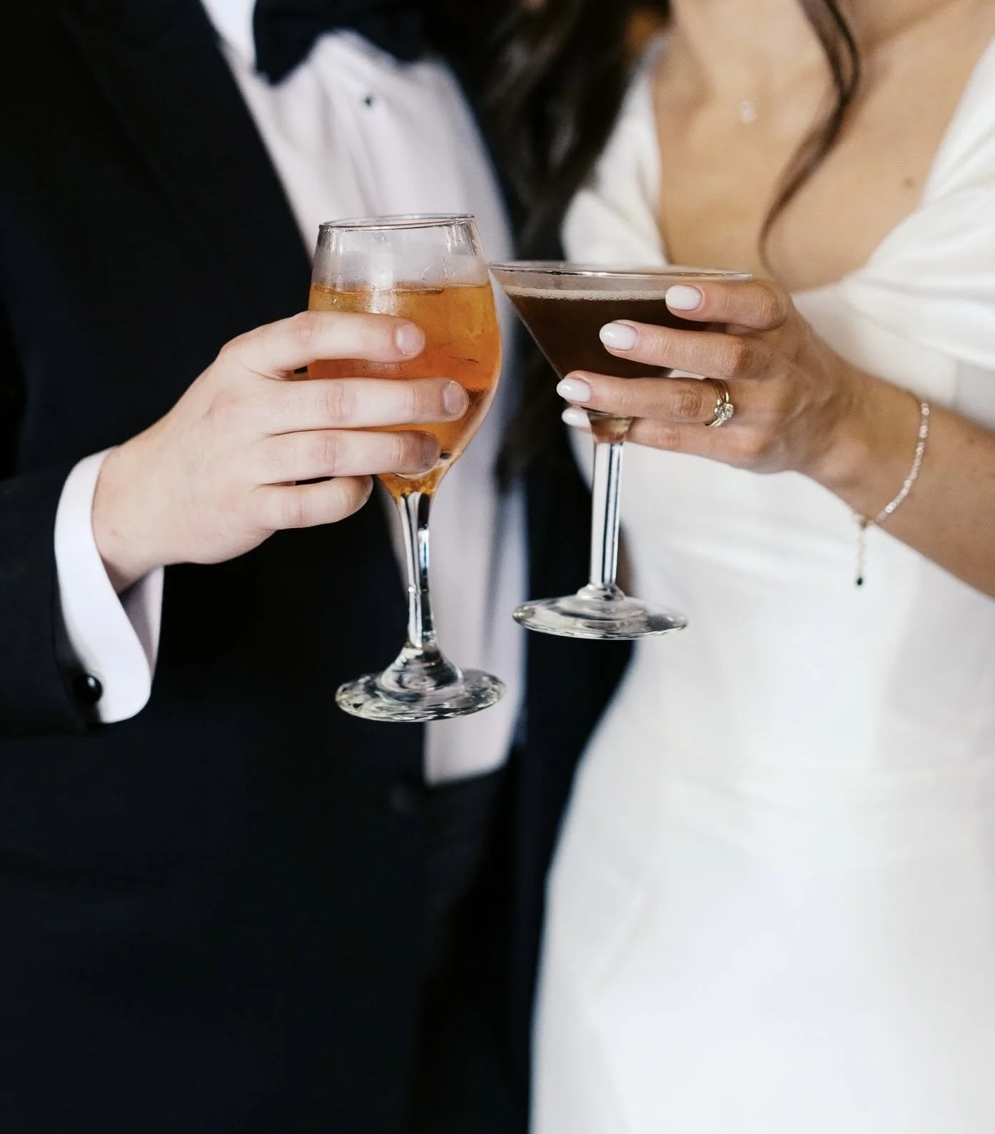 Close-up of a man and woman holding cocktails, dressed in formal attire, celebrating together at an all inclusive venue in Downtown Knoxville