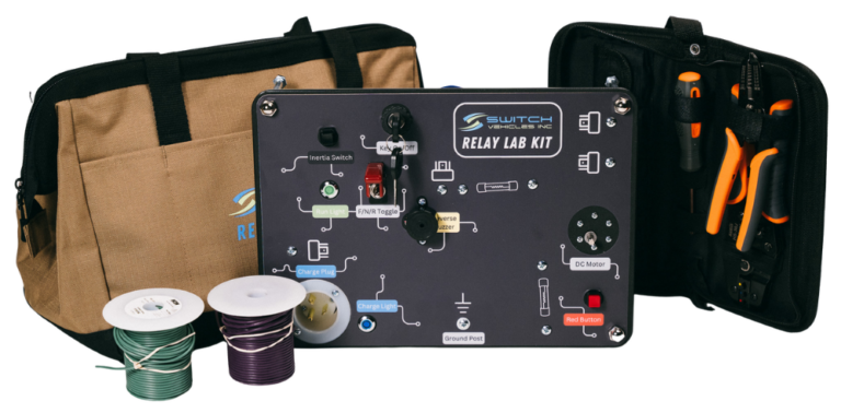 Relay lab kit including control panel with wiring diagram, rechargeable batteries, spools of wire, and a toolbox with screwdrivers and tools.