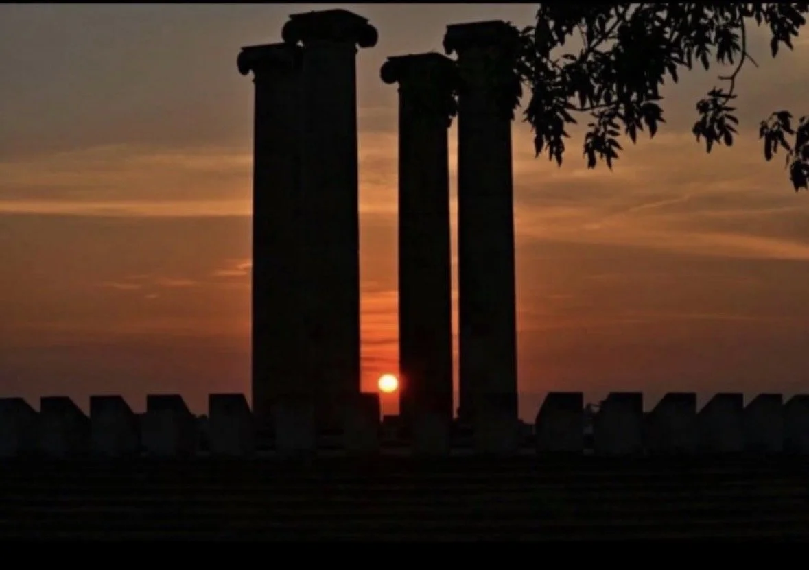 Sunset framed between the Four Freedoms Memorial pillars in Evansville, Indiana, photographed by Rob Smith