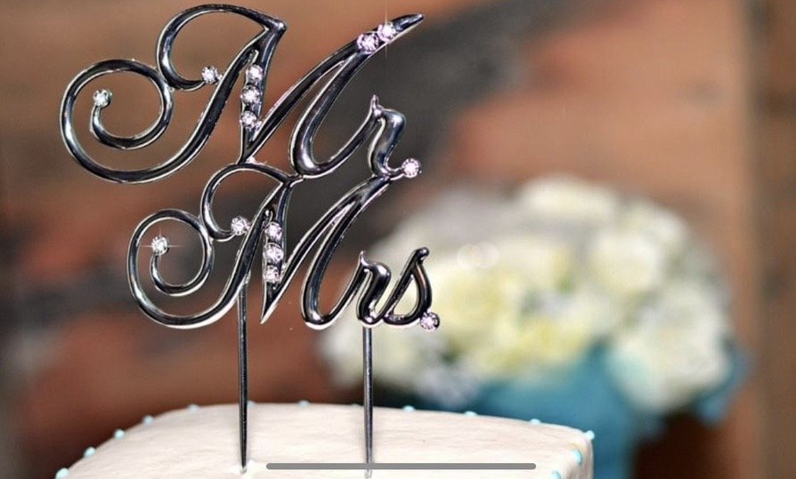 Custom wedding cake topper photographed by Rob Smith, featuring elegant calligraphy and personalized wedding décor.