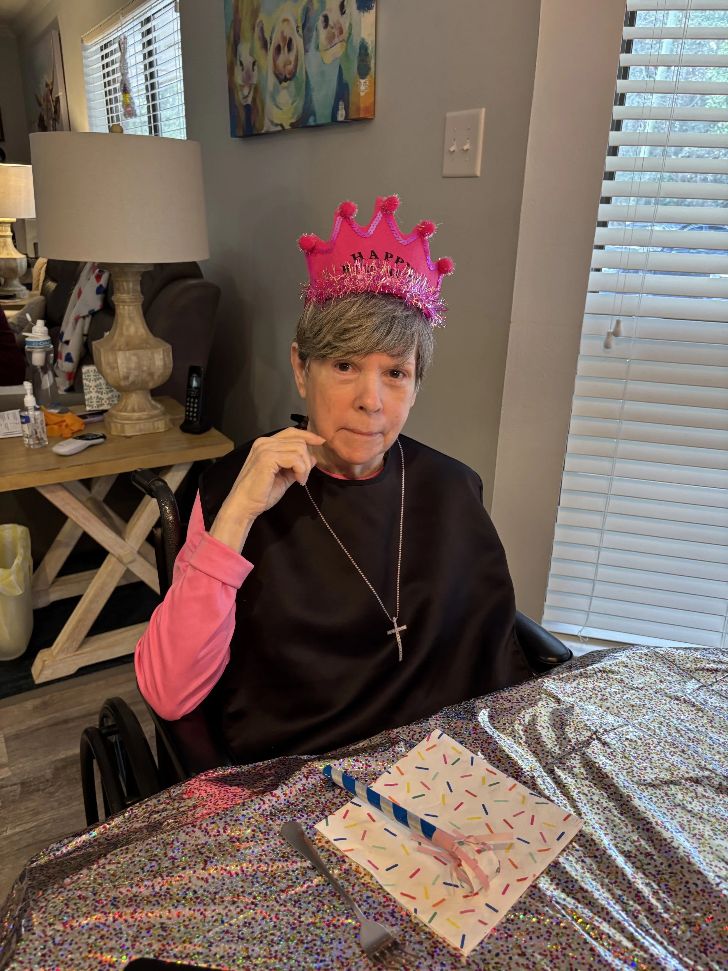 Woman with short gray hair wearing a pink 