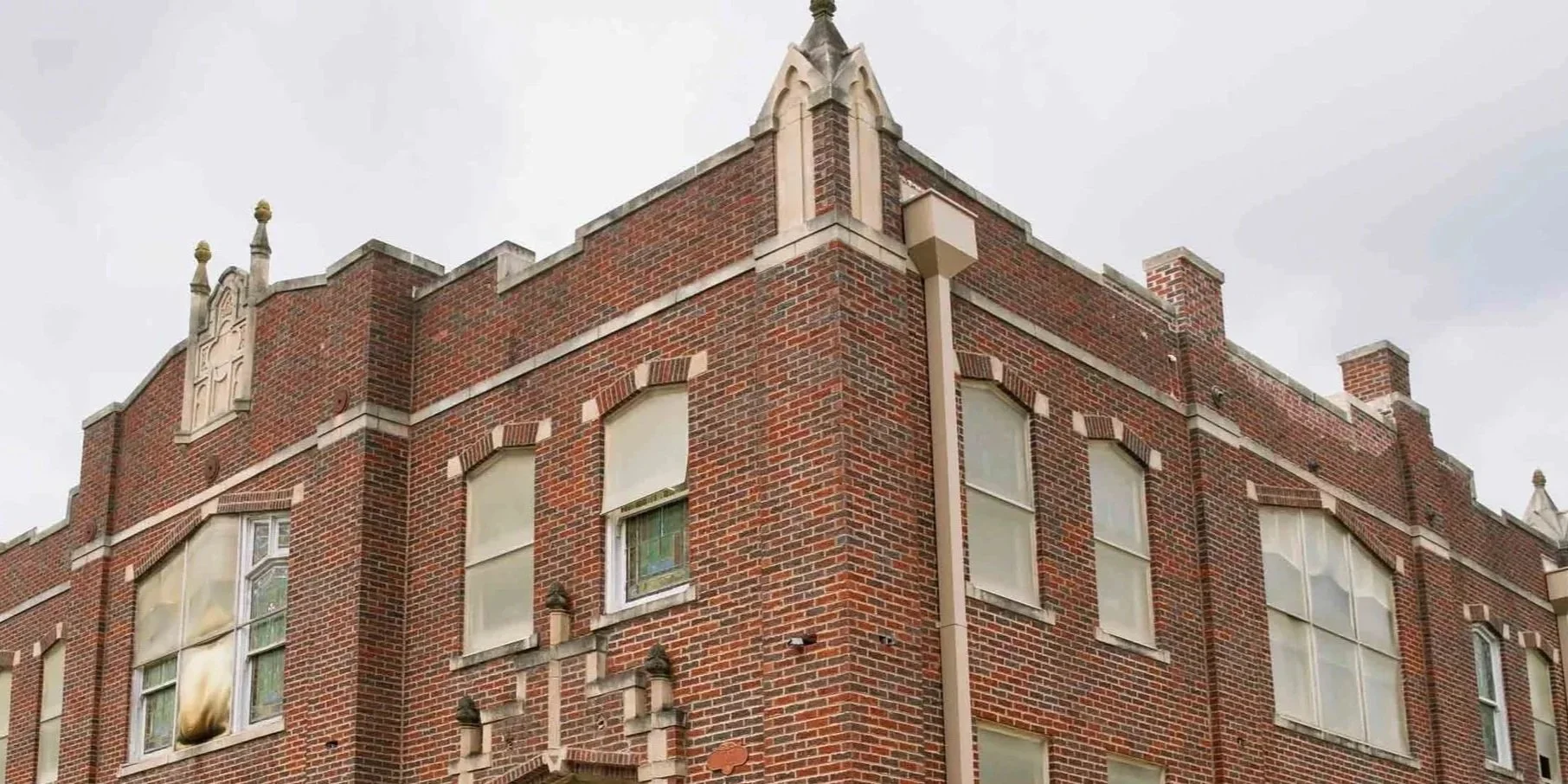 Corner of The Bradshaw in Eudora, Kansas, a historic red brick building with decorative architectural details on the roofline and windows.