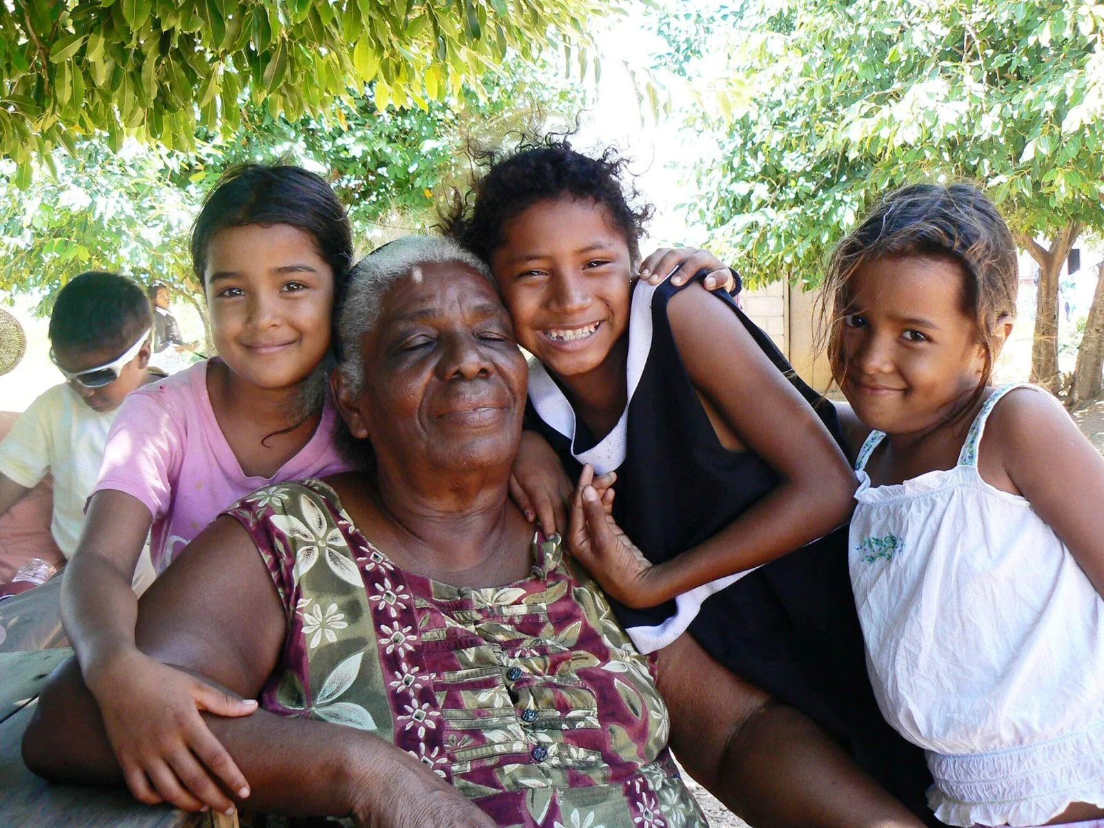Mama Tara being hugged by happy children at Mama Tara Miskito Orphanage in Honduras