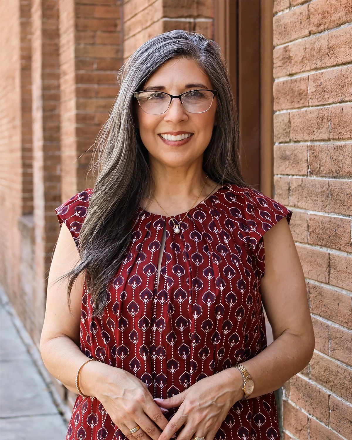Mia Celino, CPA, founder of Align Consulting Group, posing outside next to a brick wall