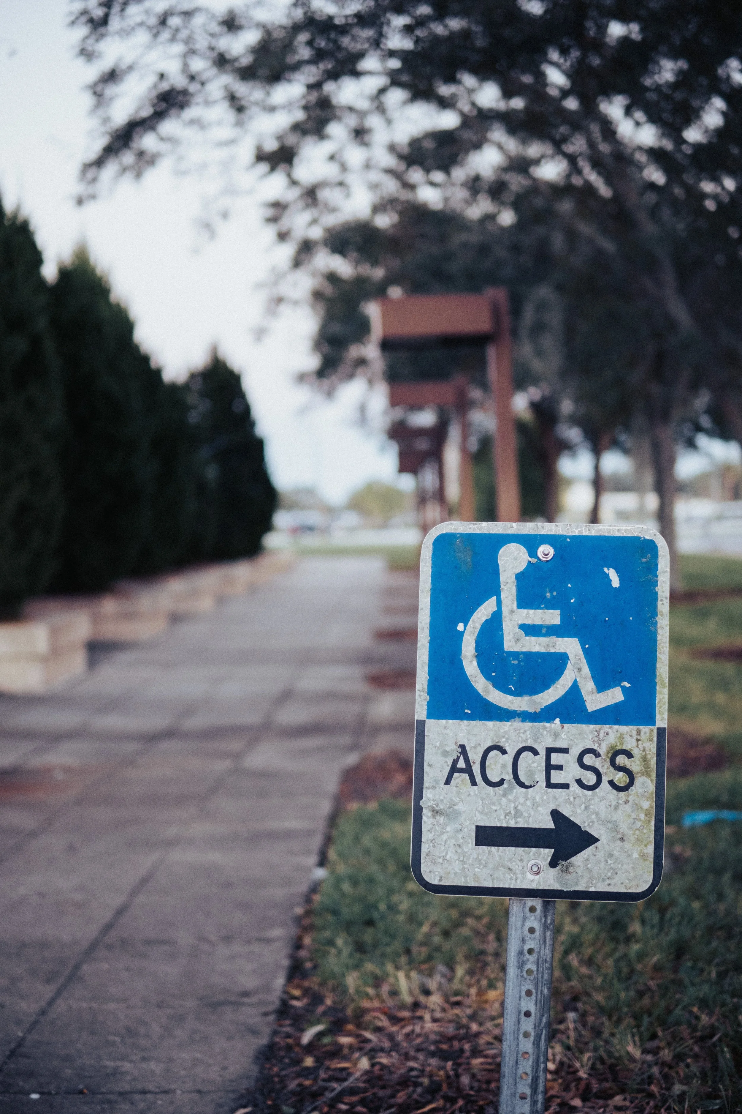A road sign reads "access" with an arrow and an image of a wheelchair