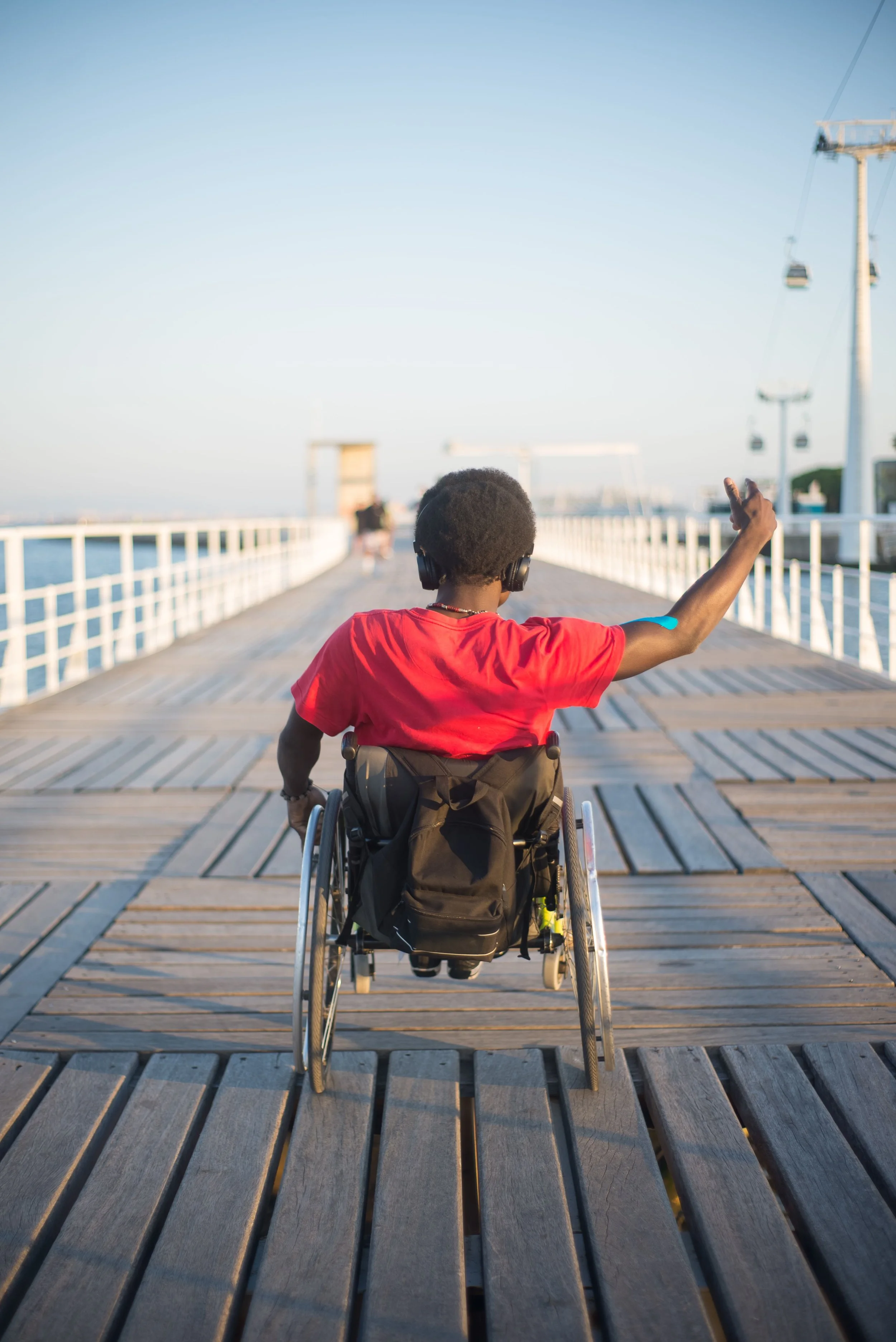 The view from behind a wheelchair user travelling down a promenade