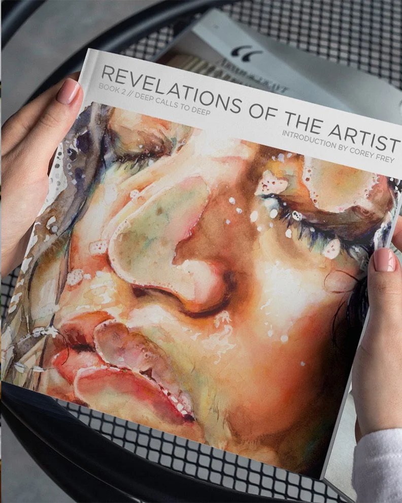 Close-up of a person holding an art book titled 'Revelations of the Artist'. The cover features a watercolor painting of a person's face with closed eyes, showcasing detailed facial features and expressive use of colors.