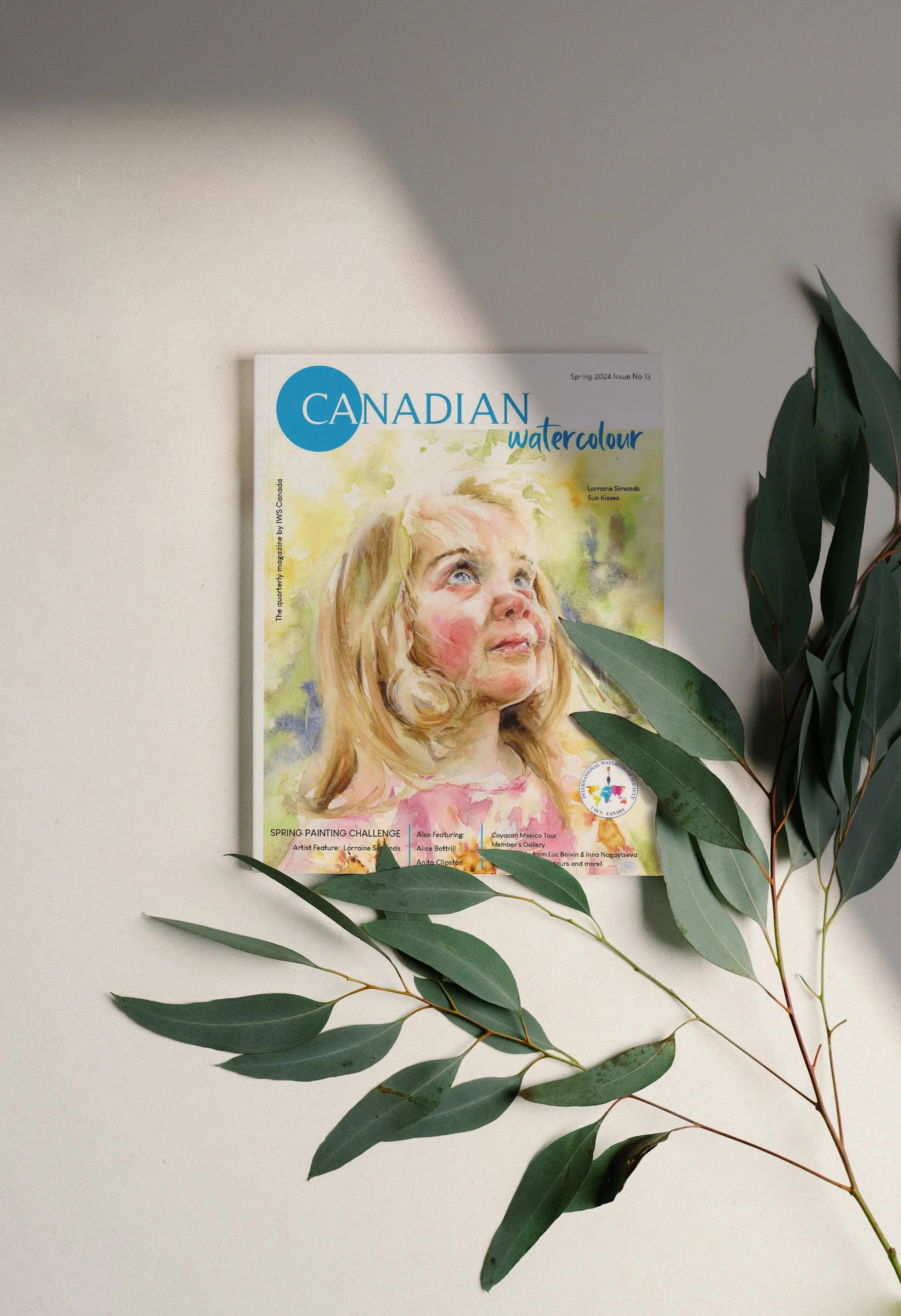 A watercolor painting of a young girl with blonde hair and blue eyes, surrounded by green foliage, on the cover of a magazine titled 'Canadian Watercolour'.
