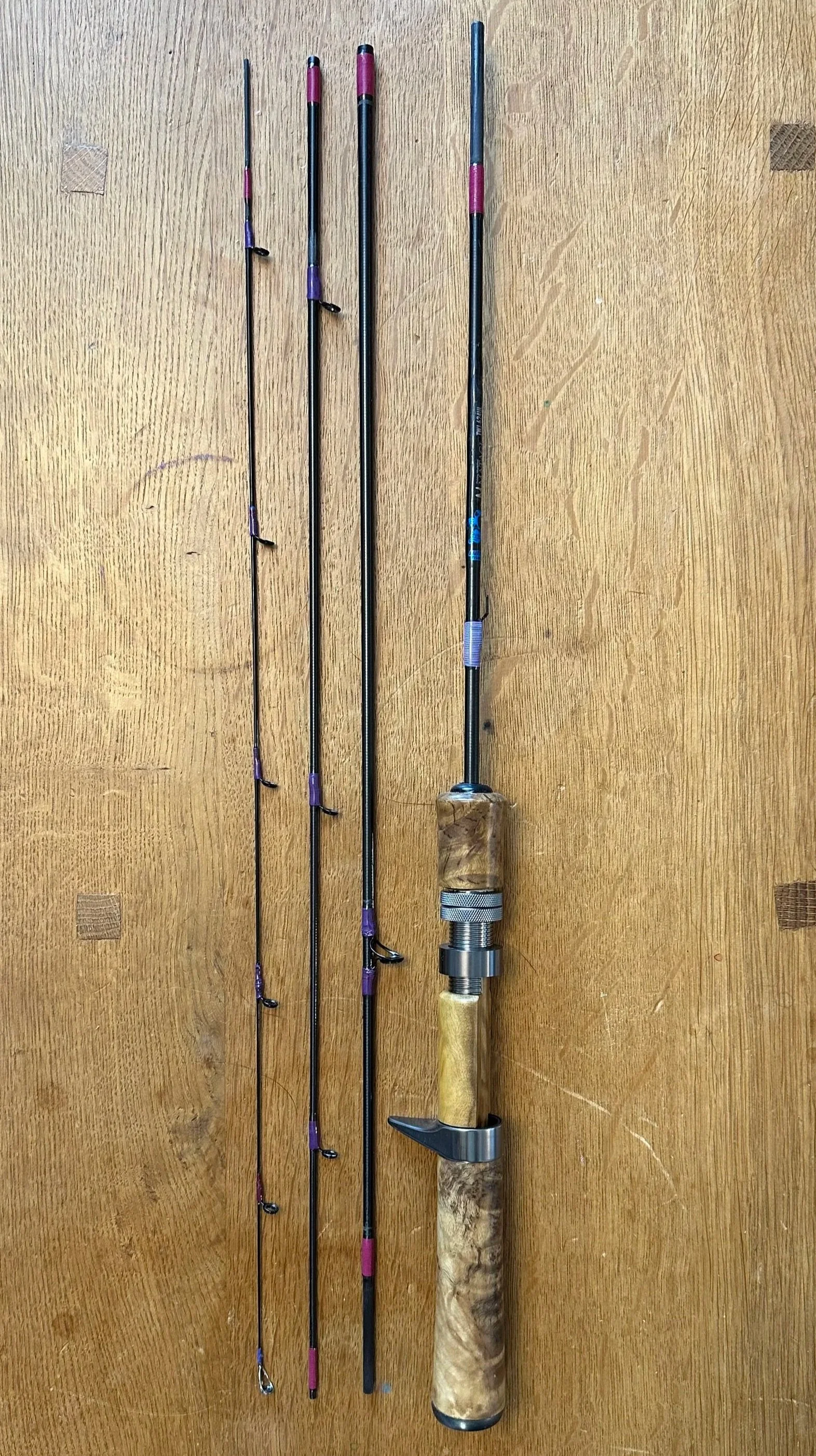 four piece fishing rod with purple and black accents and a wooden handle