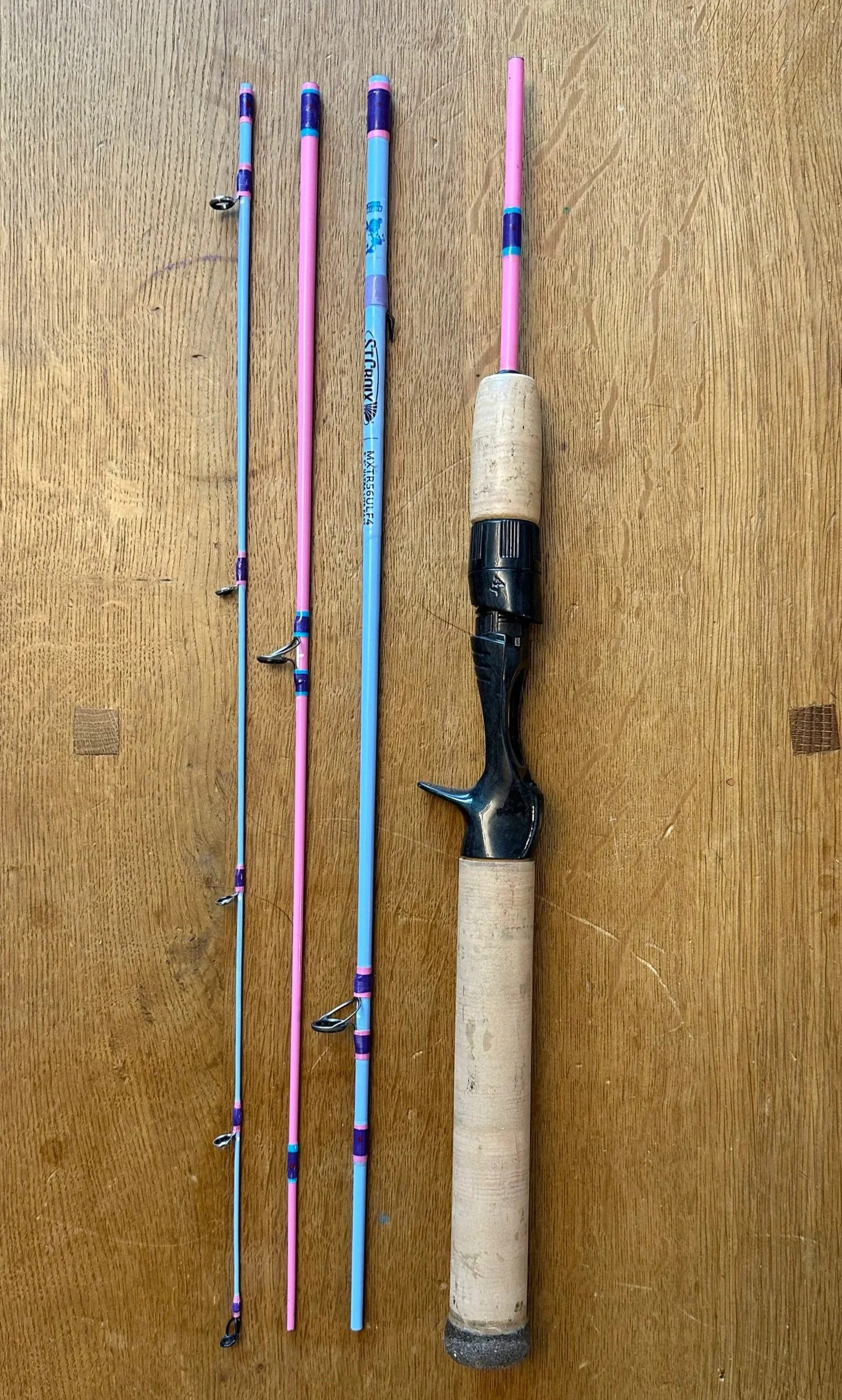 Pink and blue four piece fishing rod with a cork grip