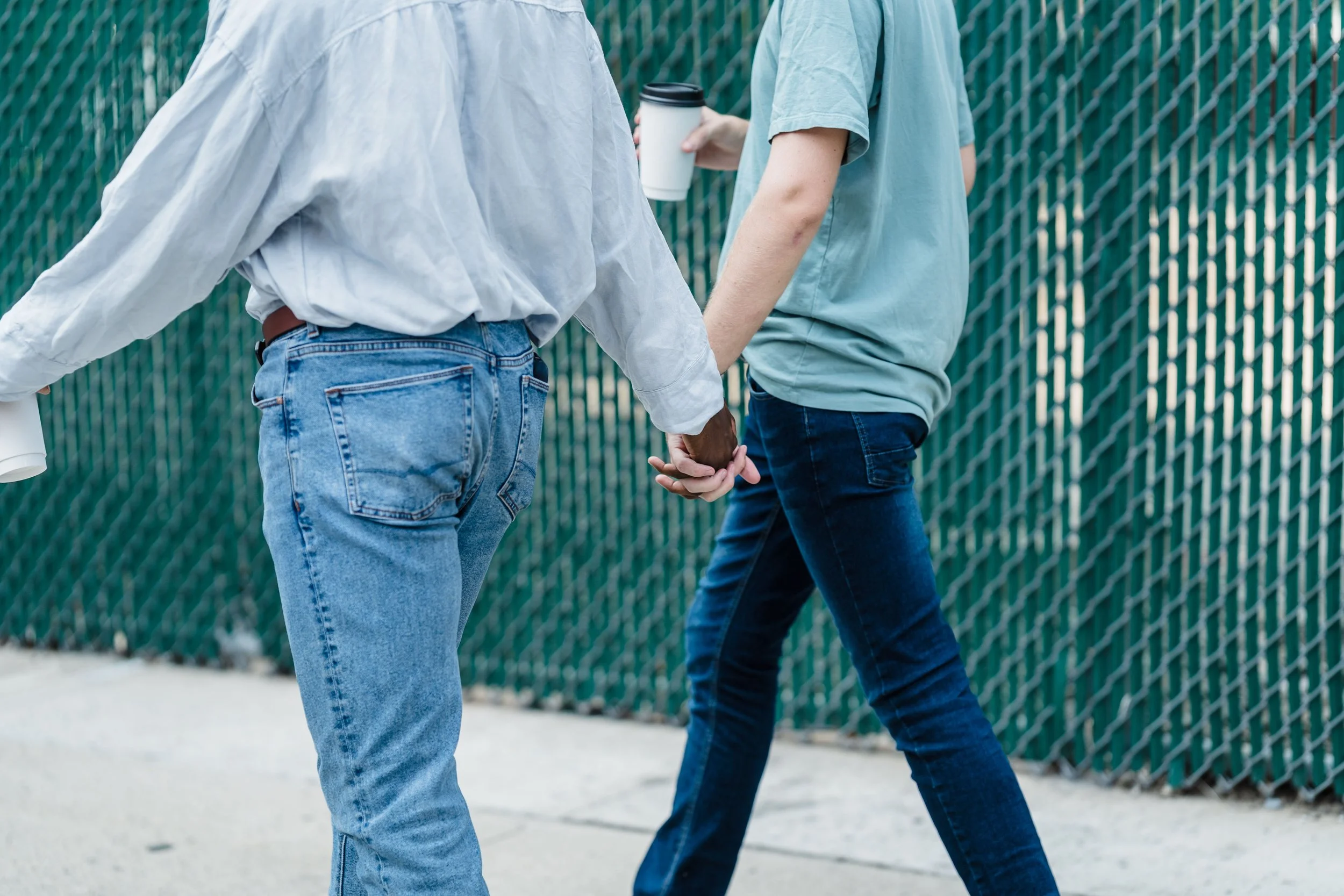 Two partners holding hands, symbolizing trust and emotional connection in couples therapy like what they would find with Dr. Mimi Chen after seeing her at her Flatiron office where she would draw from Gottman Method and Emotion Focused Therapy.