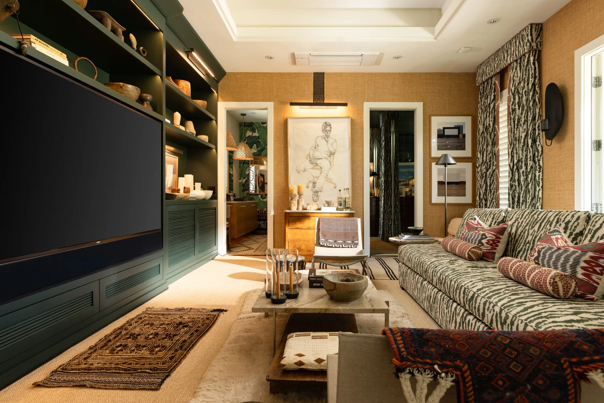 Living room with patterned furniture, artwork, and decorative items including a TV, lamps, and textiles.