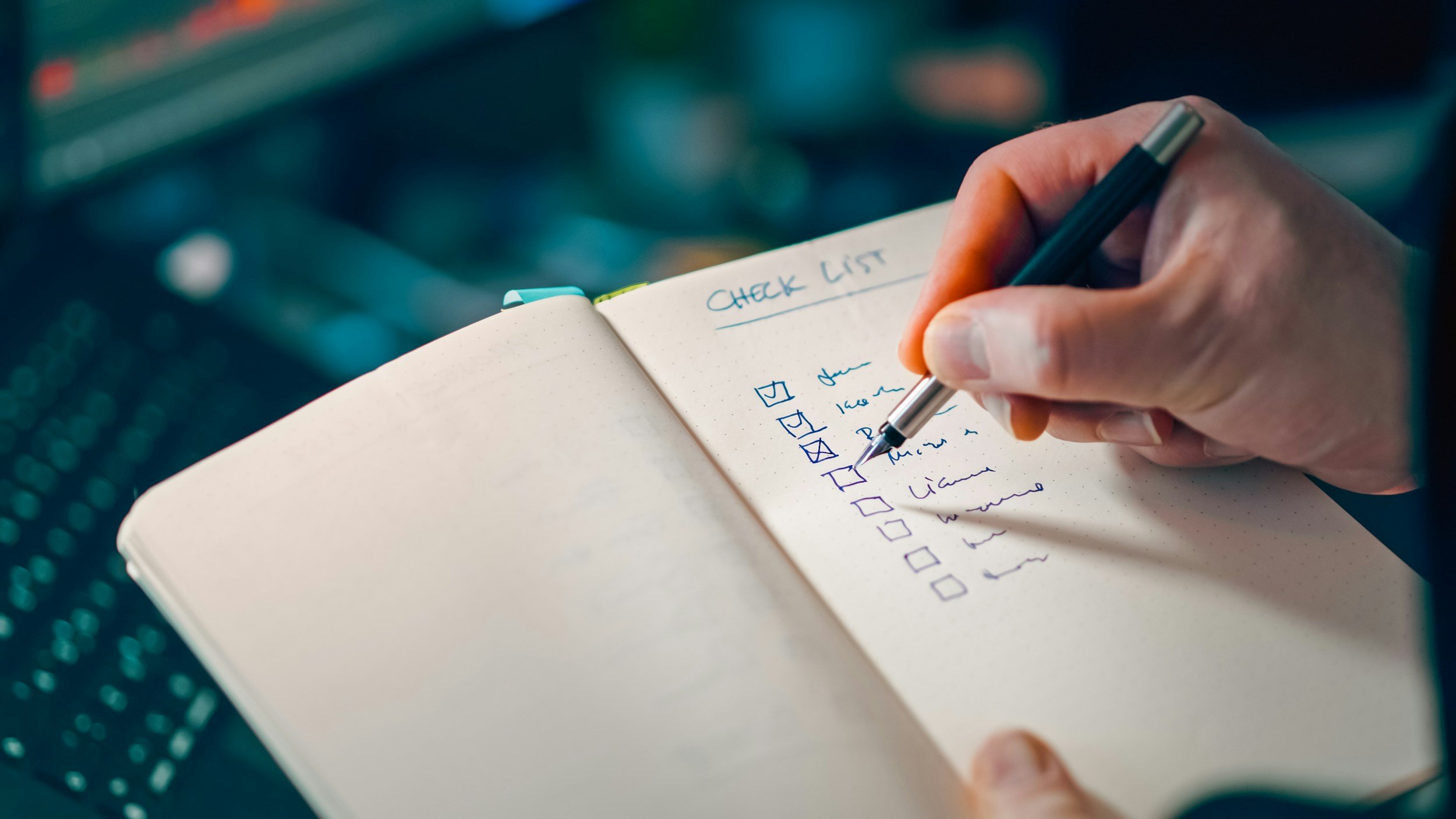 A person writing in a notebook with a check list titled 'CHECK LIST' and various items checked off.