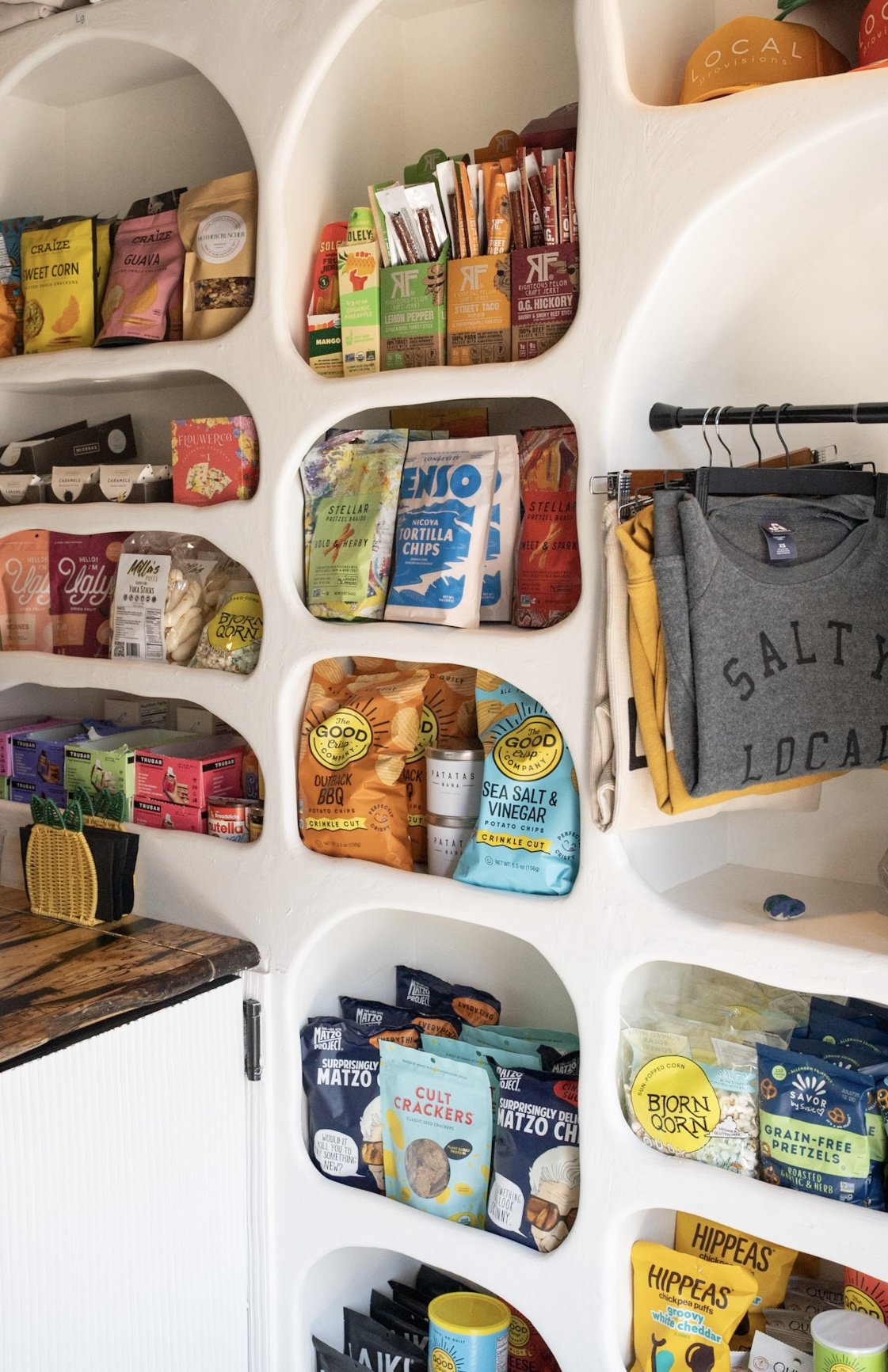Shelves with caps, clothing, snacks, and beverages