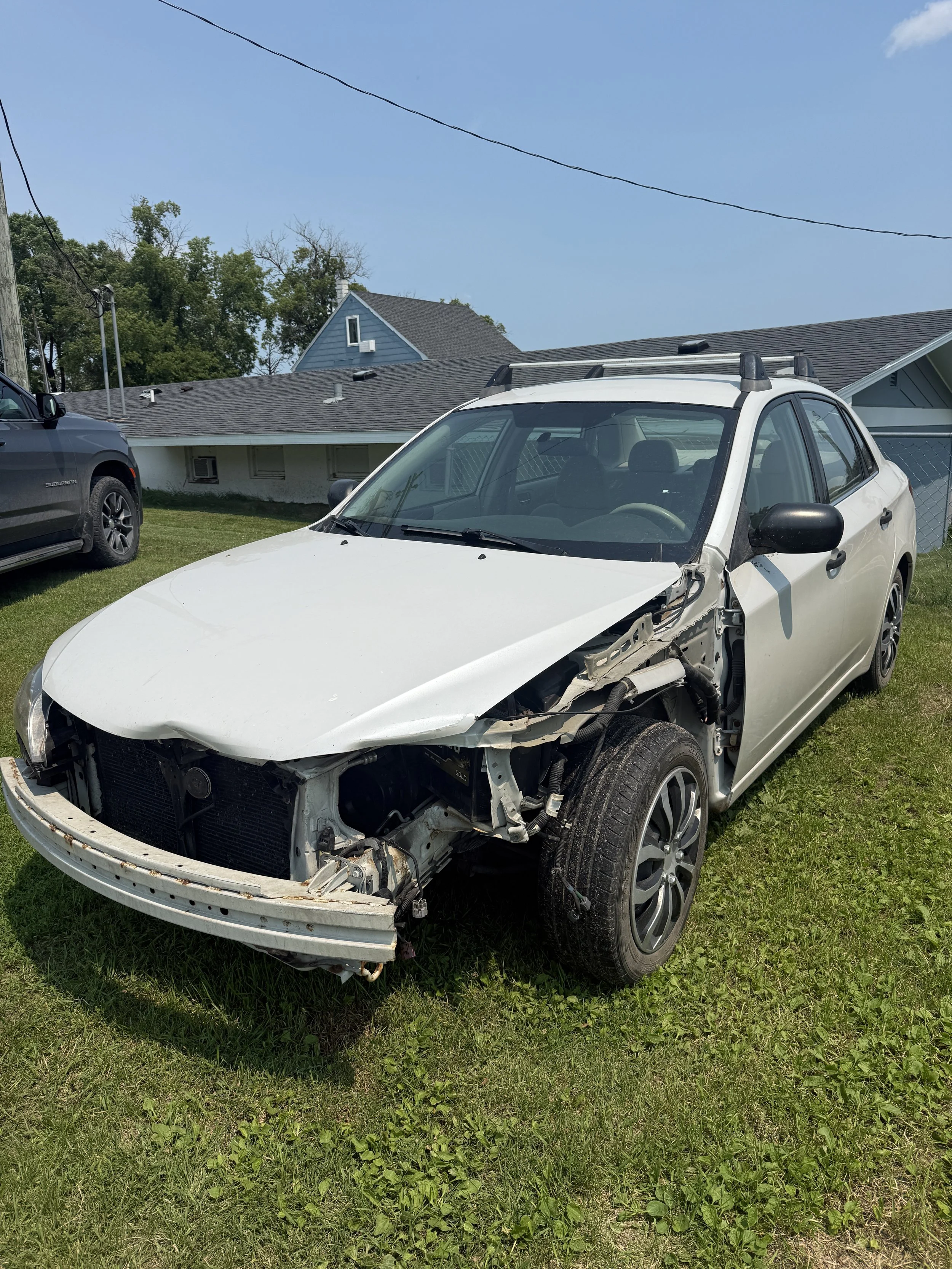 2008 Subaru Impreza after a deer collision — front-end damage to the bumper, hood, and headlight.