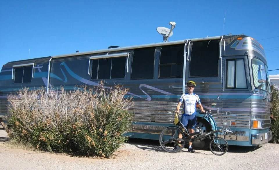 Barclay R. Brown with his bicycle beside a travel trailer