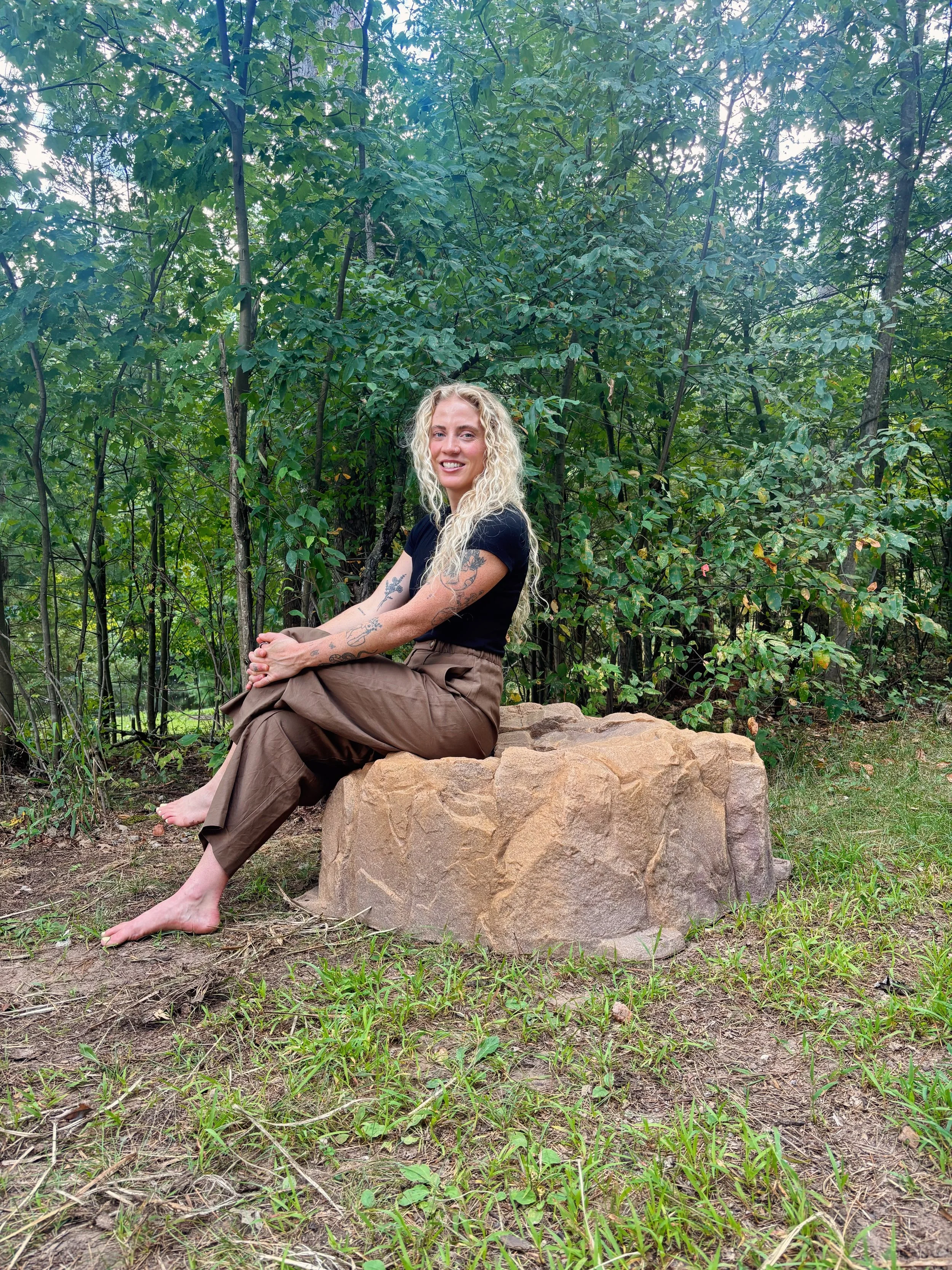 Dr. Paige Weyer smiling in a peaceful wooded setting, reflecting her holistic approach to women’s health