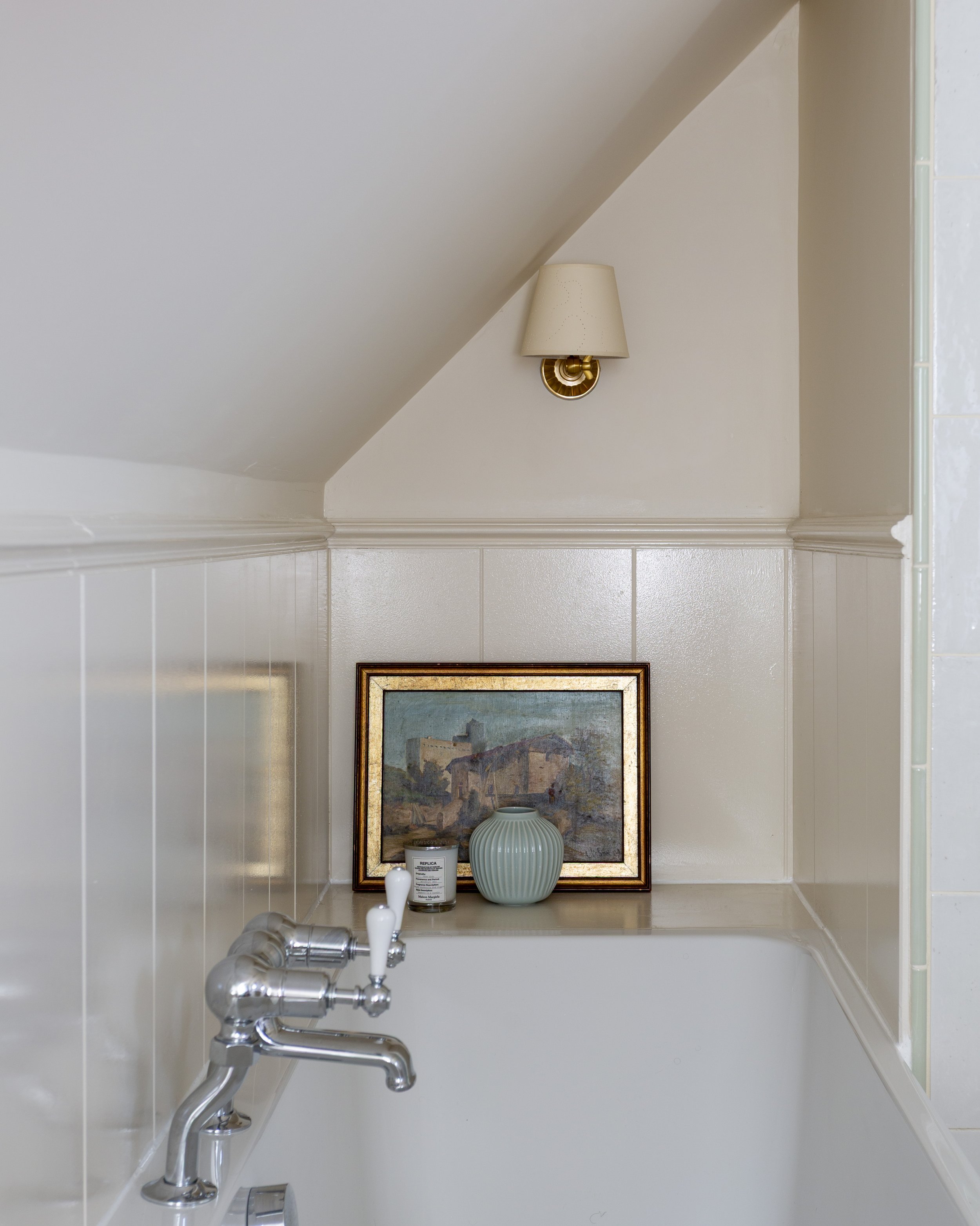 Nook with bath tucked in, vintage painting and wall light