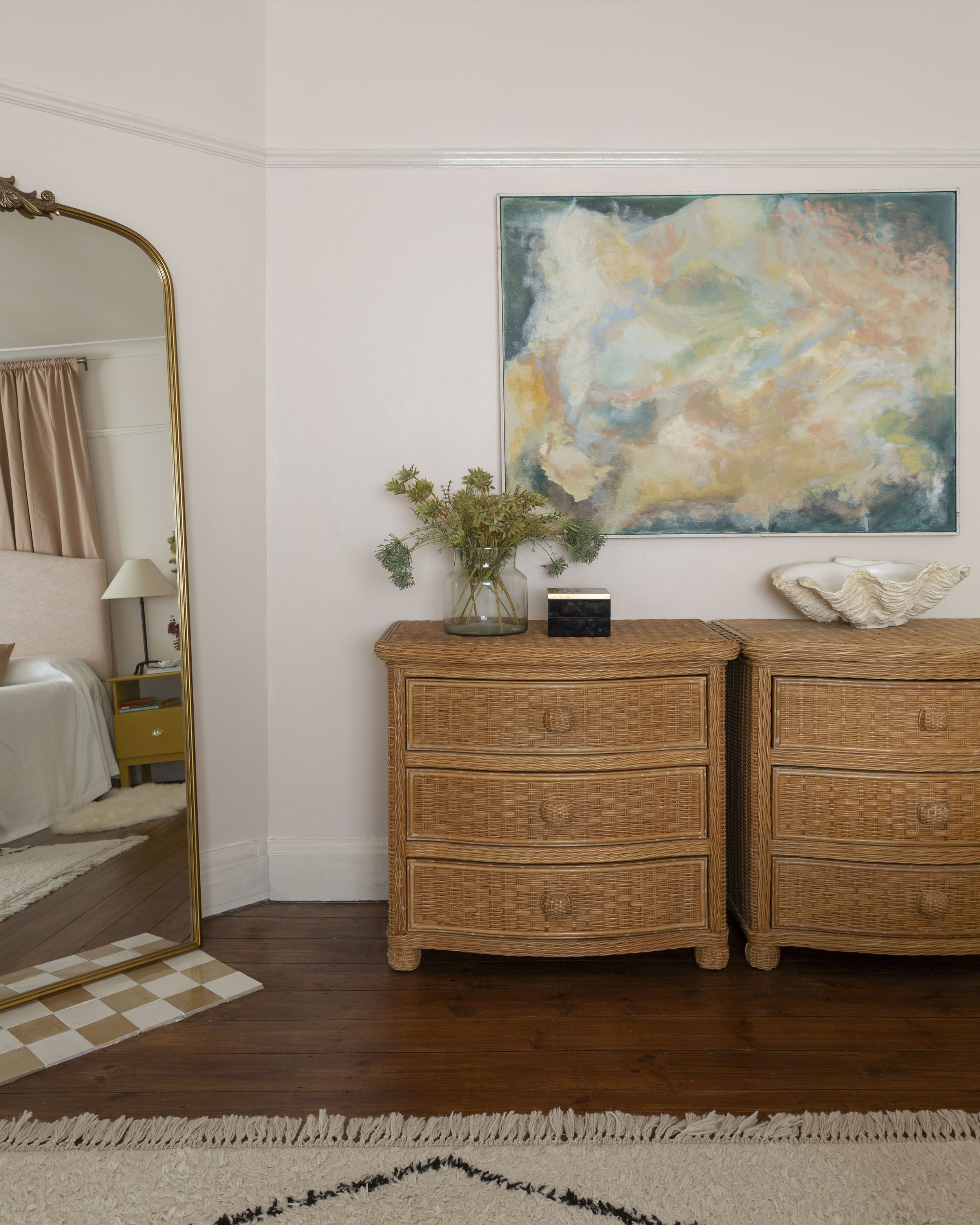 bedroom with rattan chest of drawers and large floor to ceiling mirror