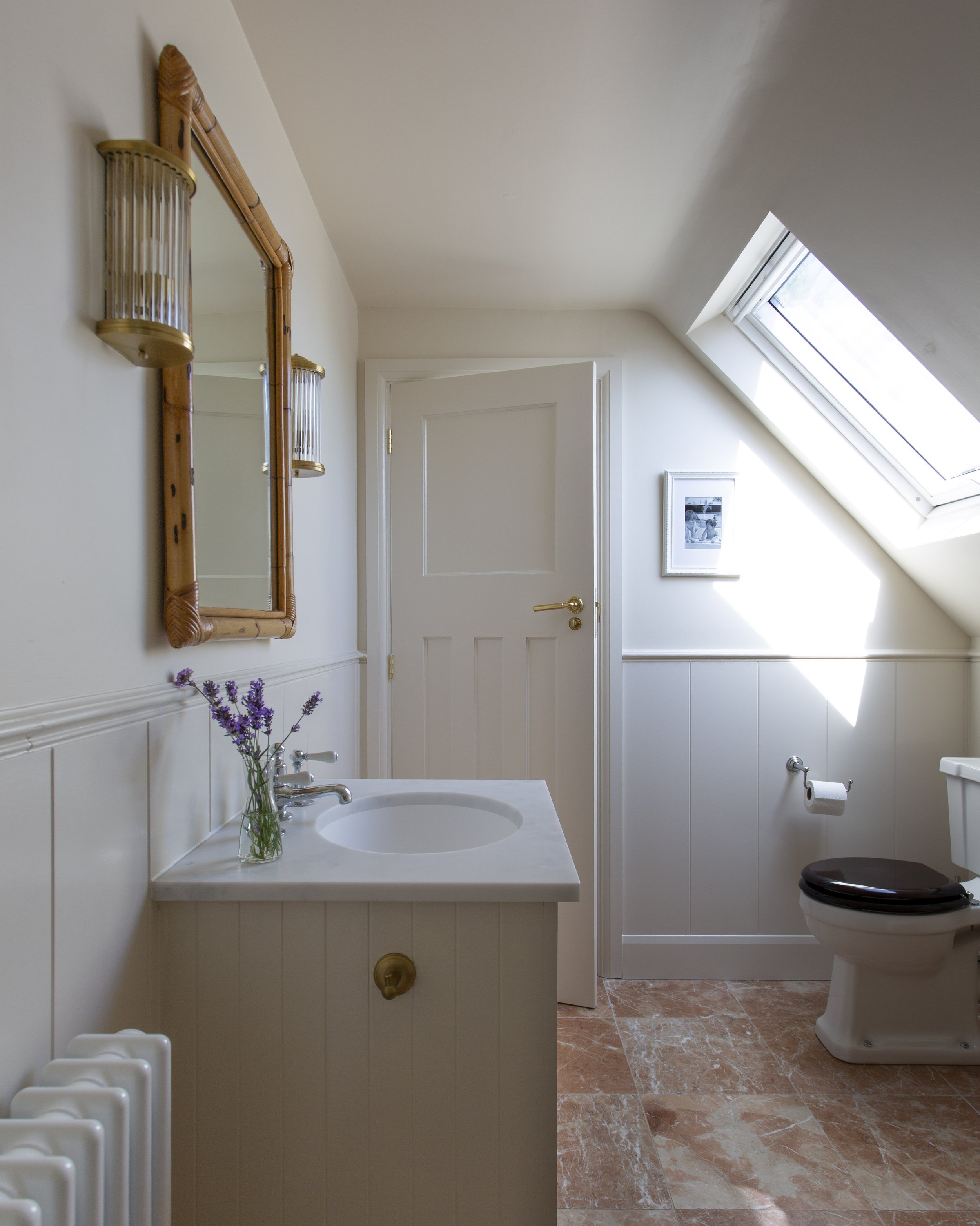 bathroom in loft with Rosso marble floors, a bathroom vanity and vintage bamboo mirror