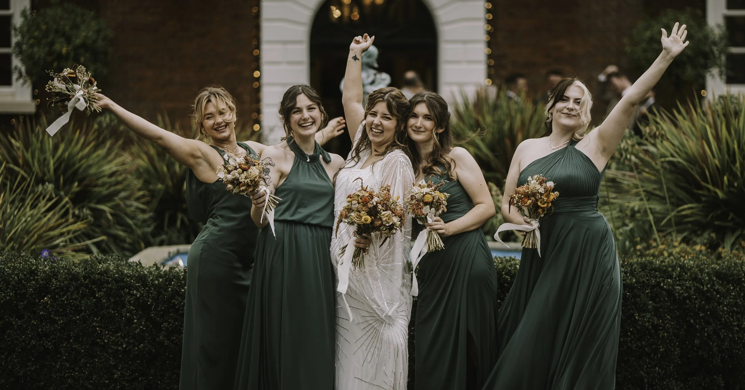 Bride celebrating with her bridesmaids outdoors after the wedding ceremony.