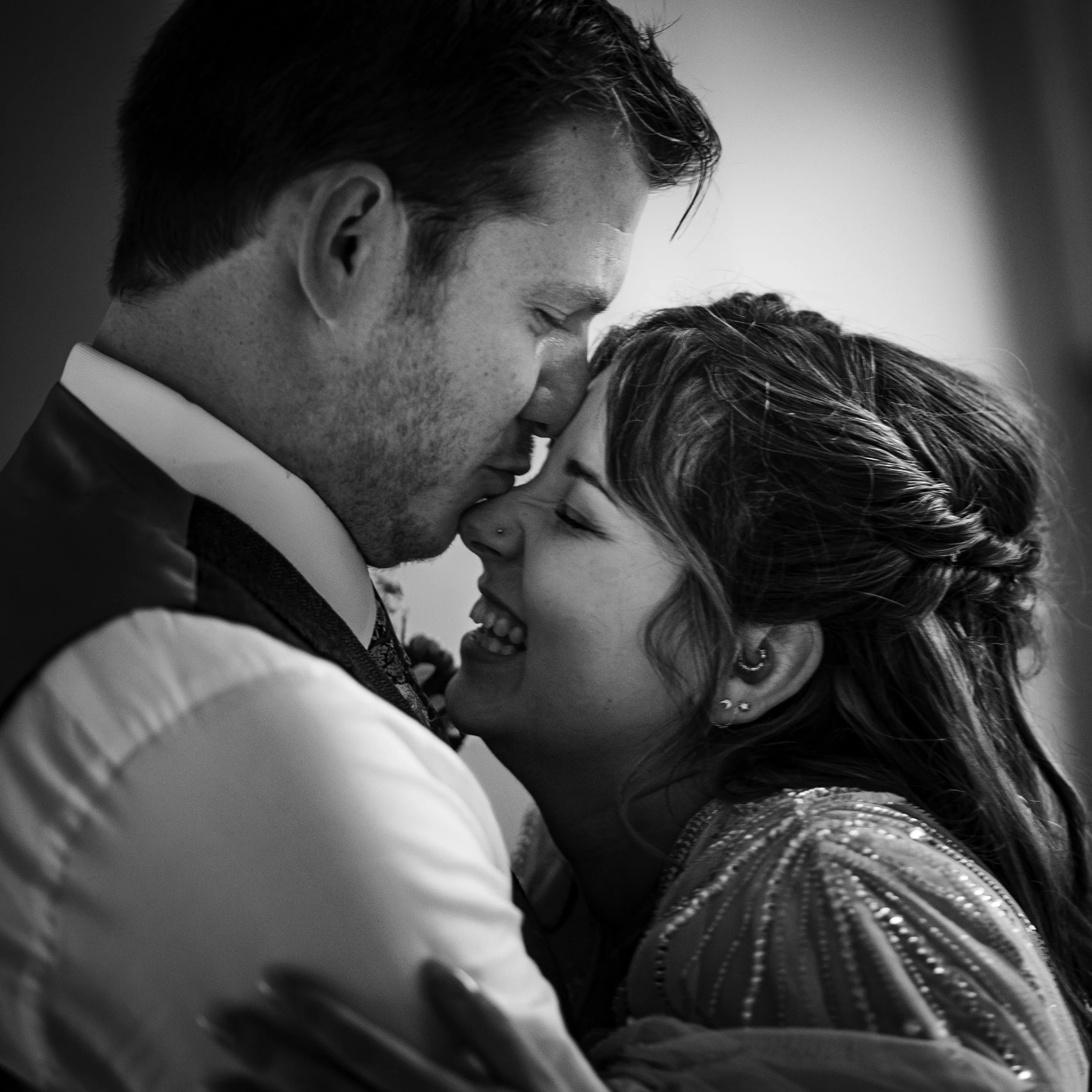 Close-up of a man and woman with their foreheads and eyes touching, showing intimacy and affection in black and white.
