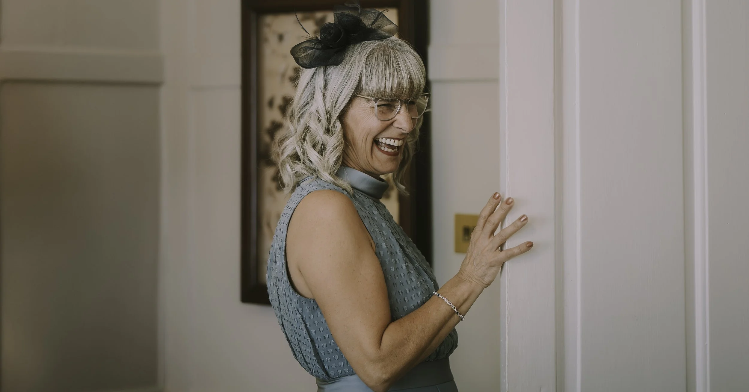 Mother of the bride smiling as she watches the wedding preparations.