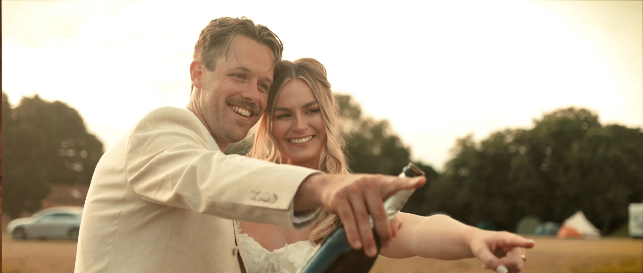 Newly married couple laughing together during golden hour outside their family barn wedding, featured in a cinematic wedding film.