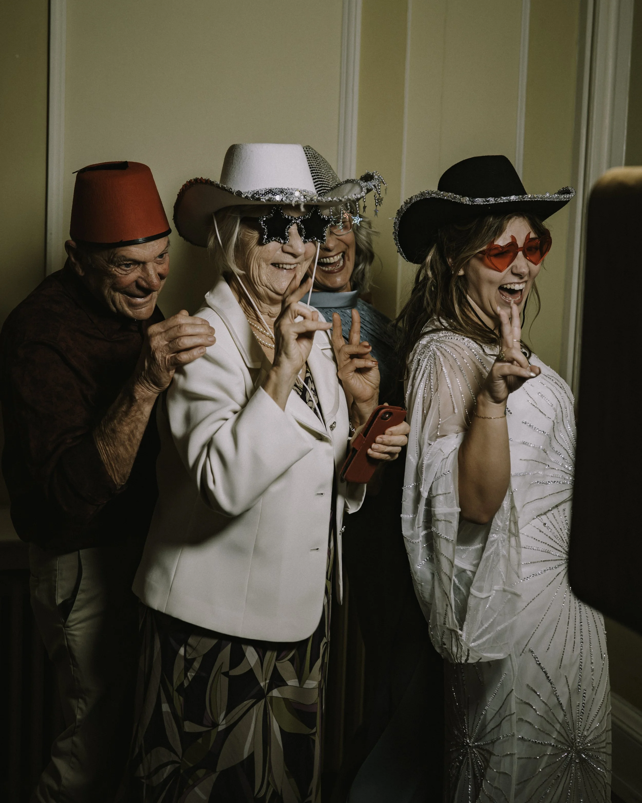 Wedding guests laughing together in the photo booth during the evening reception at the Assembly House, Norwich.