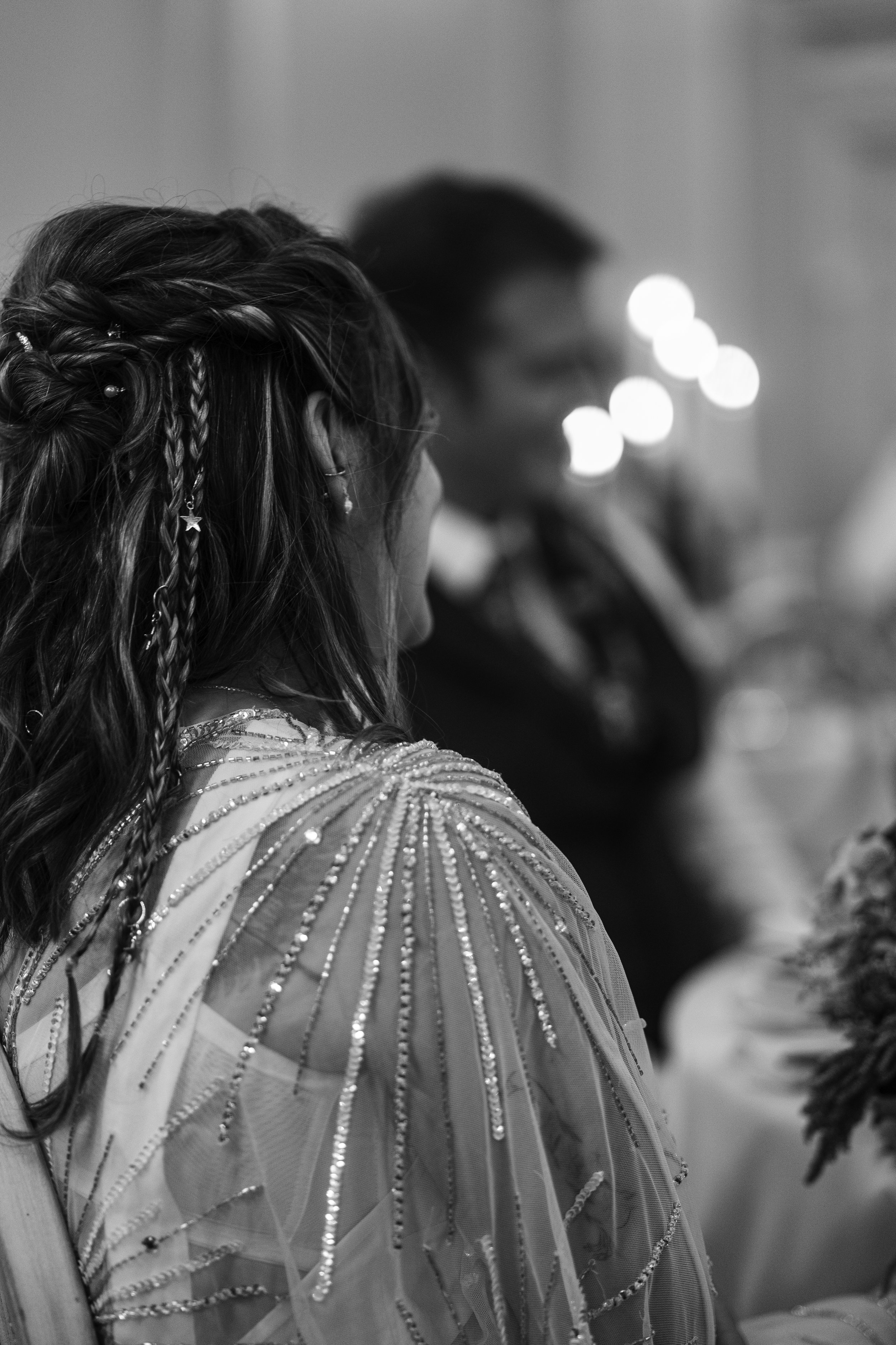 Black and white portrait of the bride during the wedding reception, illuminated by candlelight.