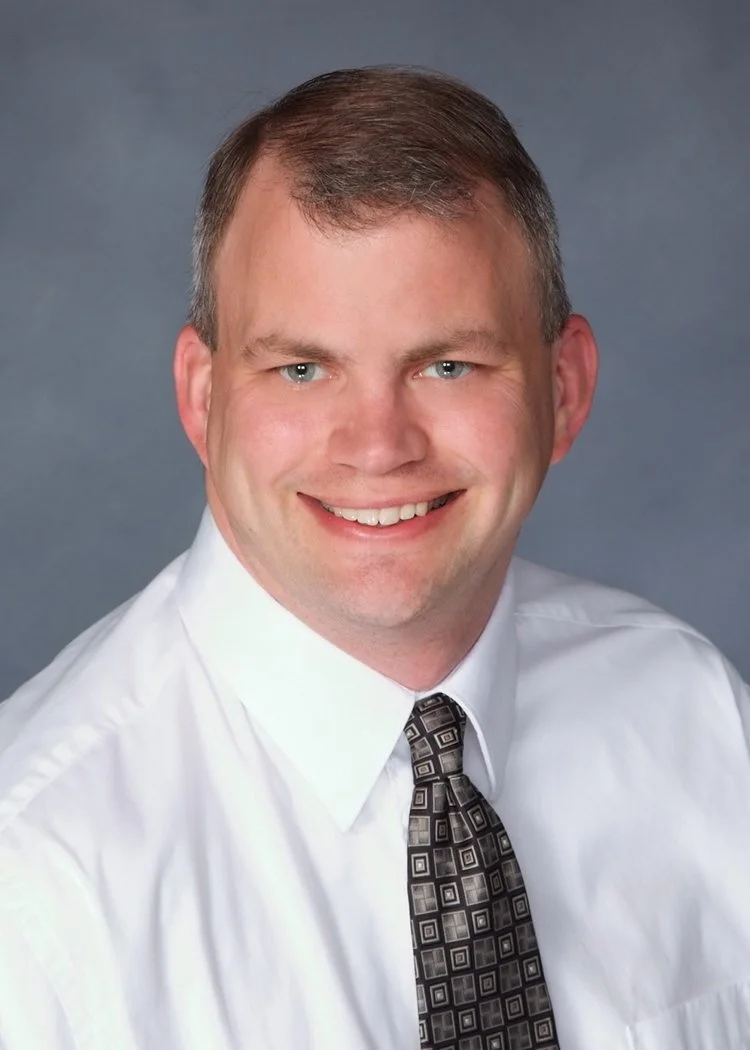 Professional headshot of Mark Thompson, DVM, MBA, CCRP, smiling against a gray background.