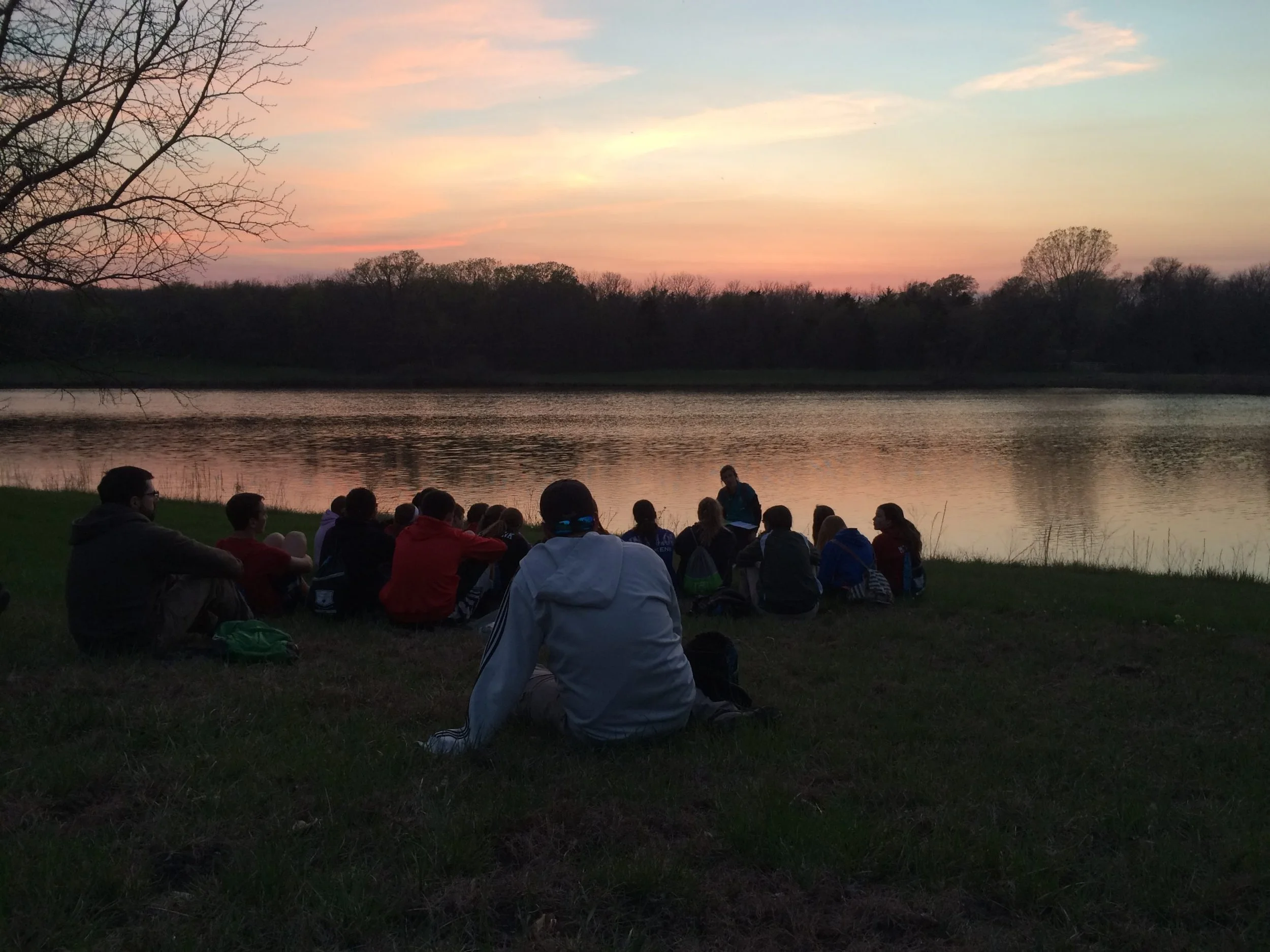 Lake-at-sunset-with-kids-sitting-on-shore-scaled.jpg