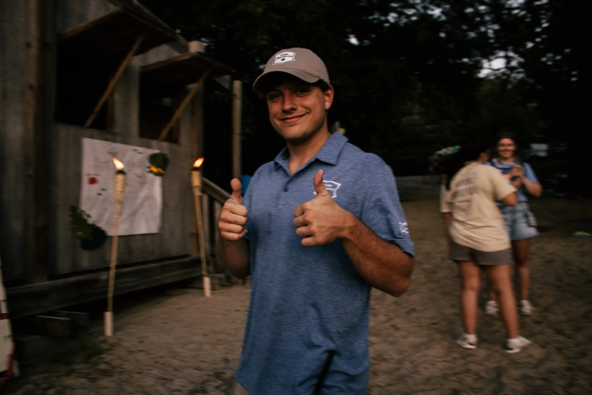 A man smiling with thumbs up outside
