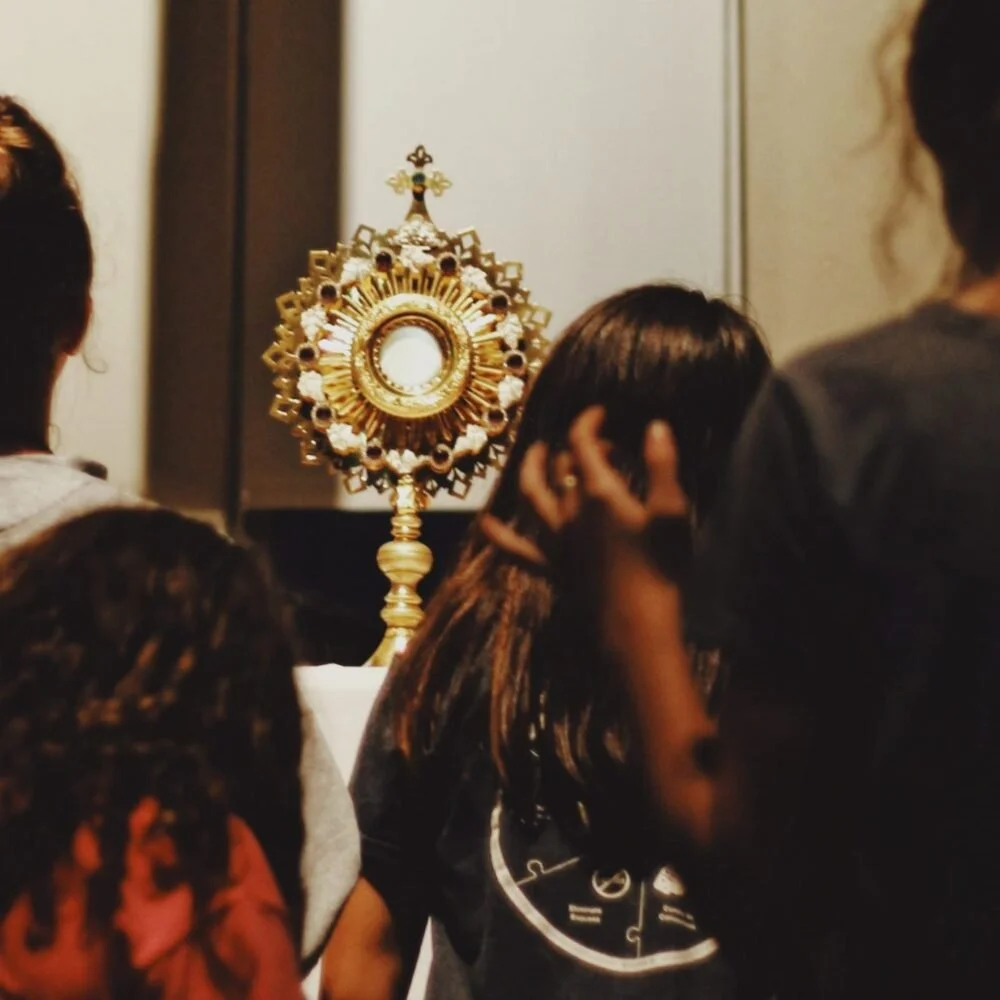 People gathered around a monstrance during a religious procession or prayer service.