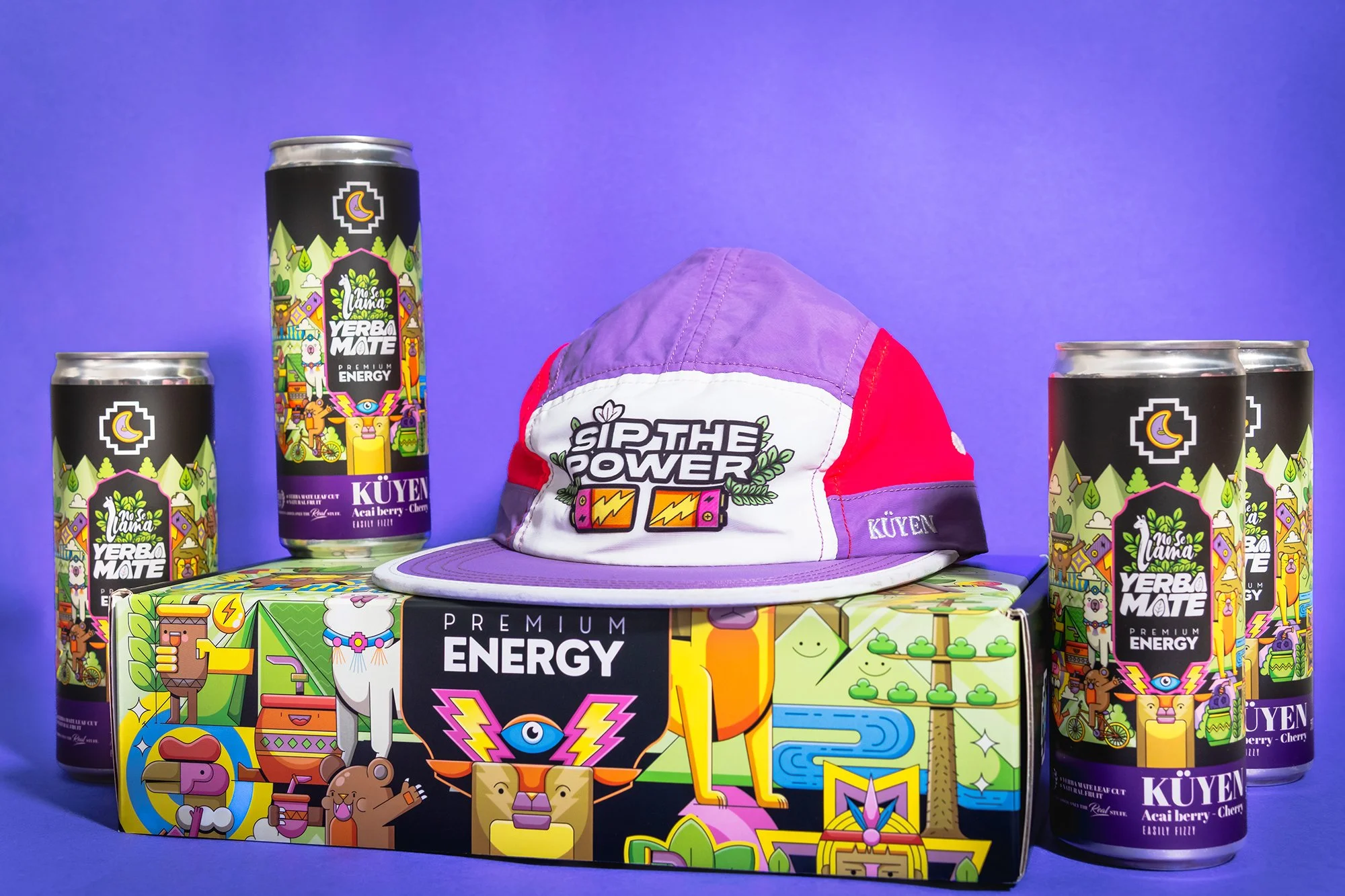 A collection of energy drink cans, a colorful box, and a cap with vibrant, cartoon-style graphics on a bright blue background.