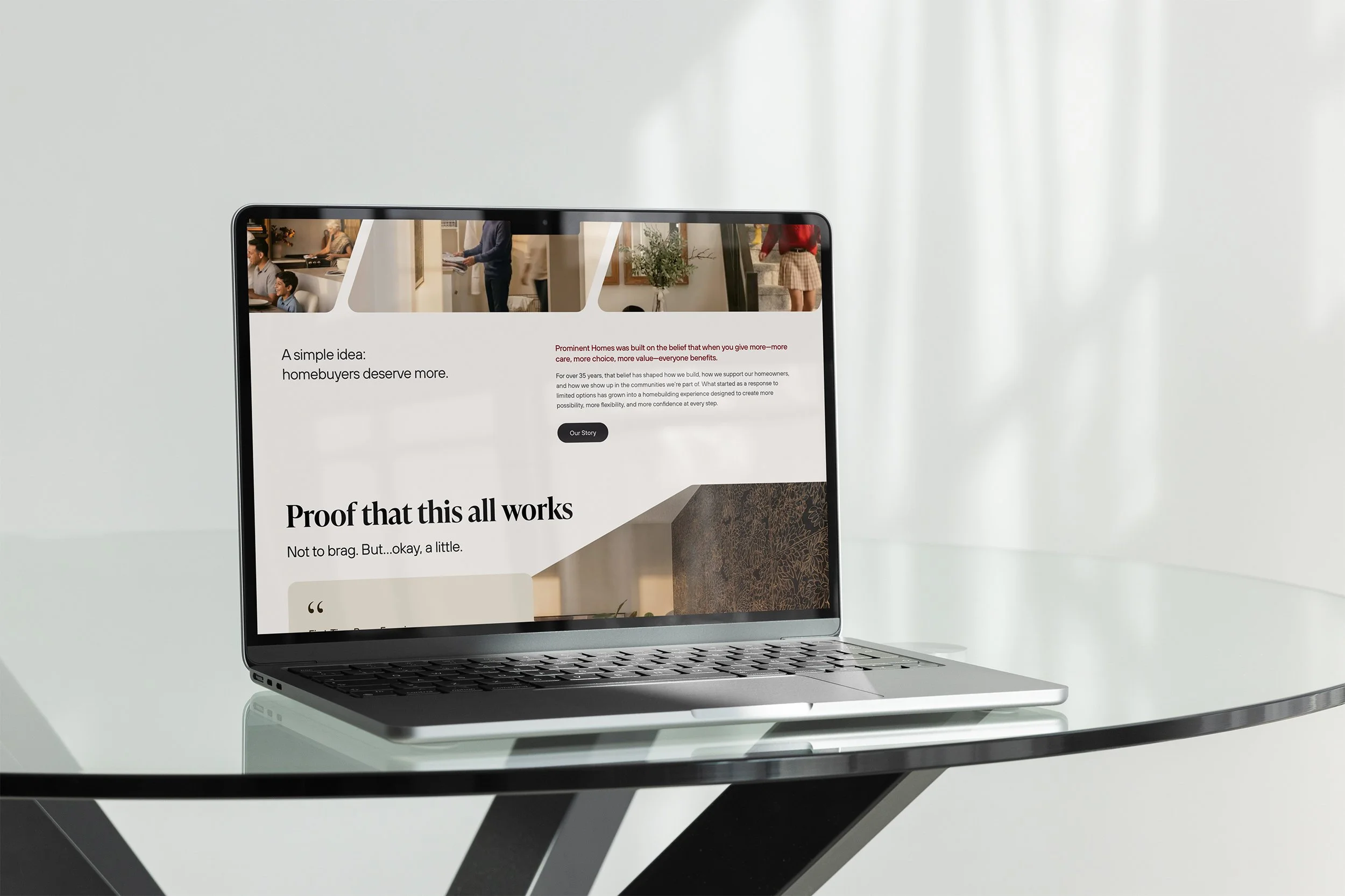 A silver laptop on a black and white tracked table displaying a homebuyers website with images of happy families and a headline about homeownership benefits.