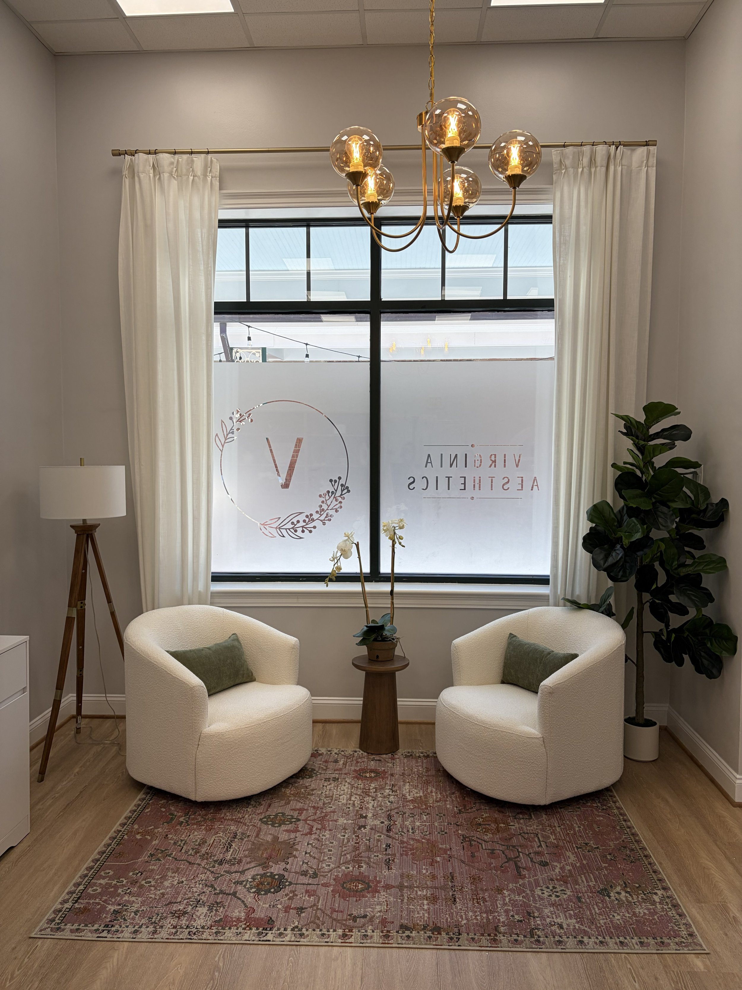 Lobby with cream chairs plants and lamp with window with logo