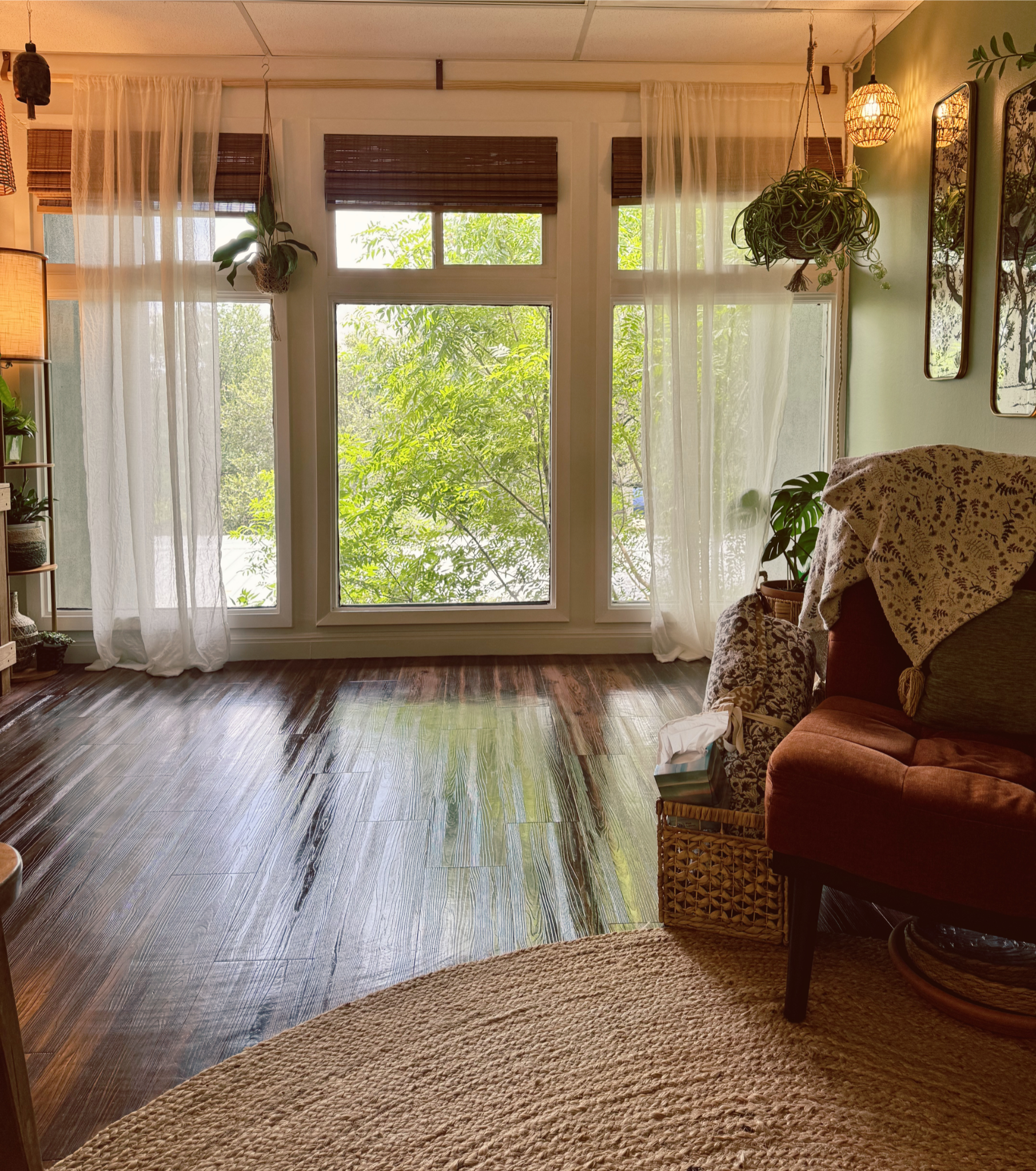 light-filled, open office space with wood floors, large windows, plants, and a comfortable chair