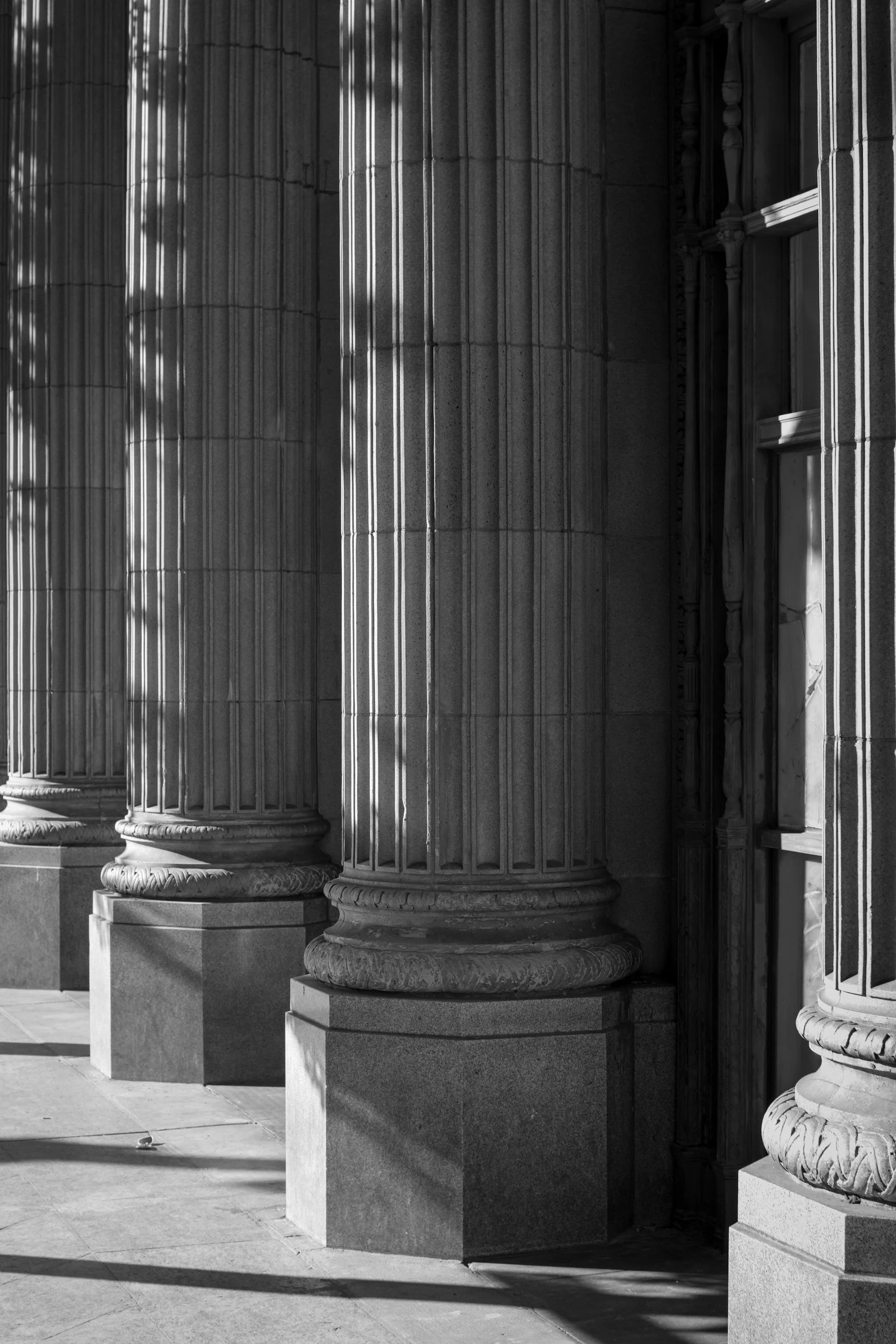 Black and white photo of large classical columns with ornate bases and fluted shafts