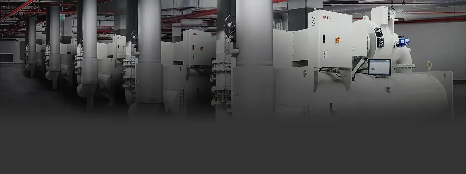Imagen de una sala de máquinas con equipos industriales grandes y tuberías, utilizados probablemente para procesos de producción o generación de energía.