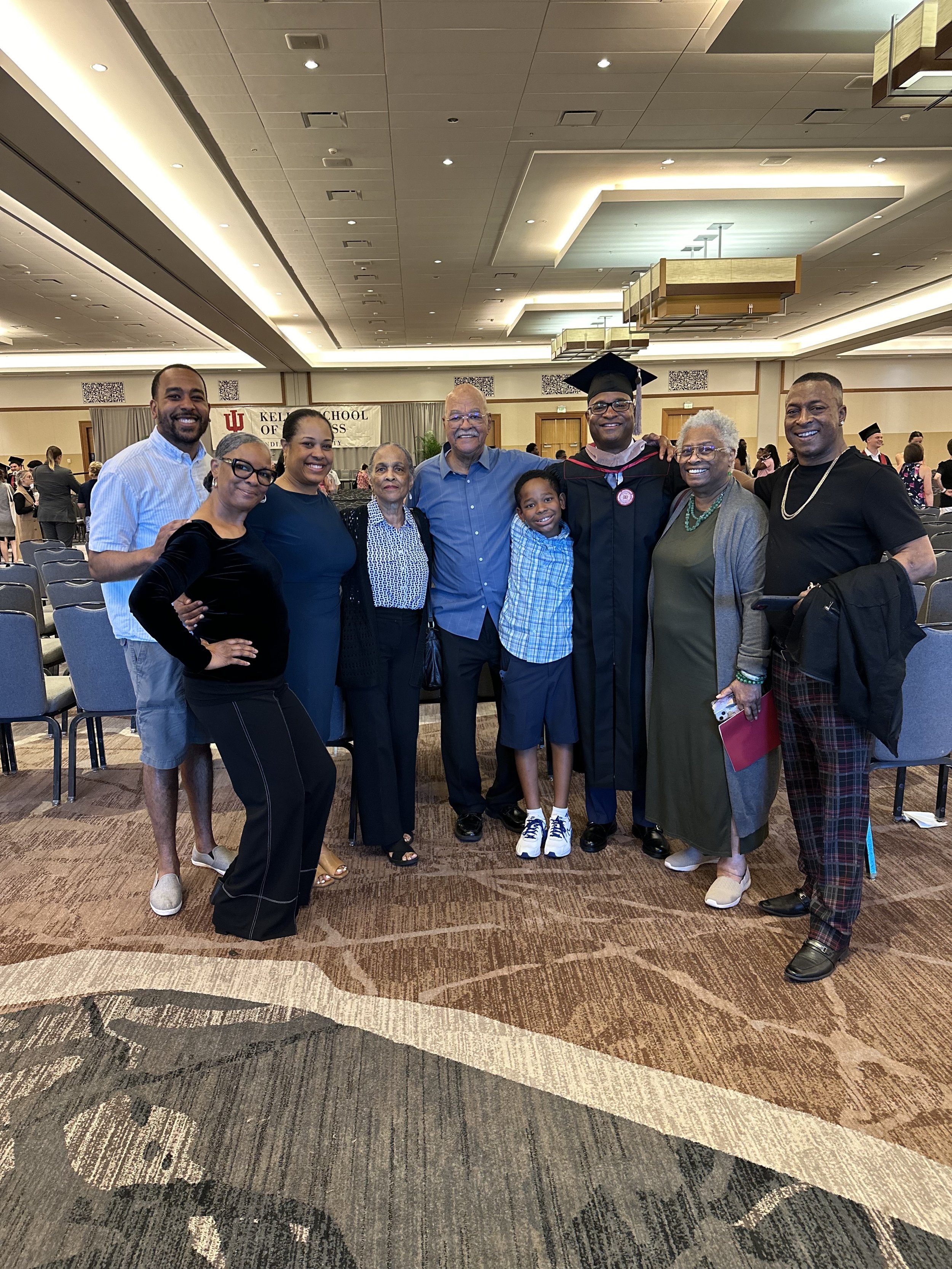 Charles in graduation regalia, surrounded by family and friends.