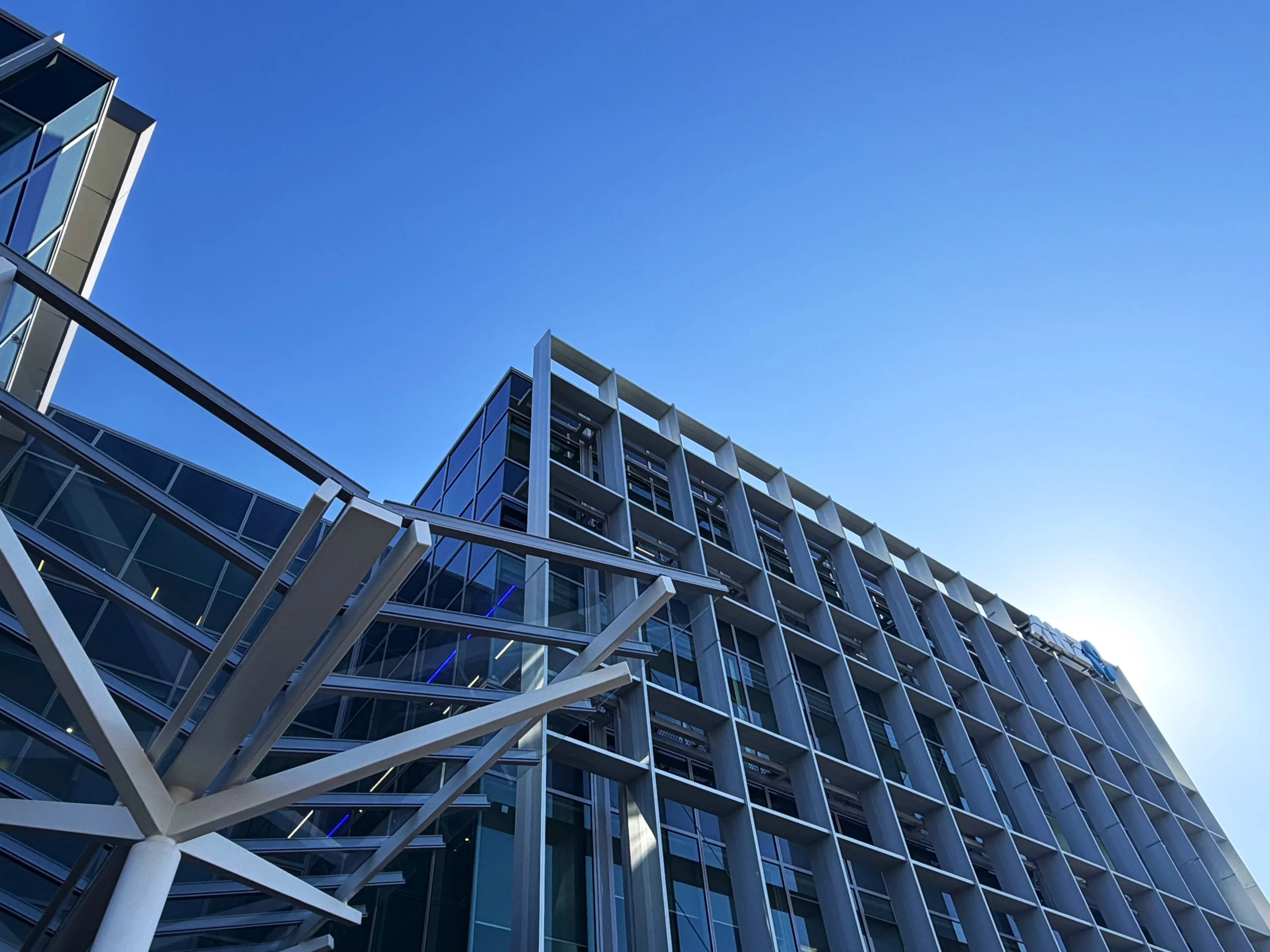 ANZ Centre Cameron Road, Tauranga. Modern multi-story building with glass windows and white structural elements against a clear blue sky.