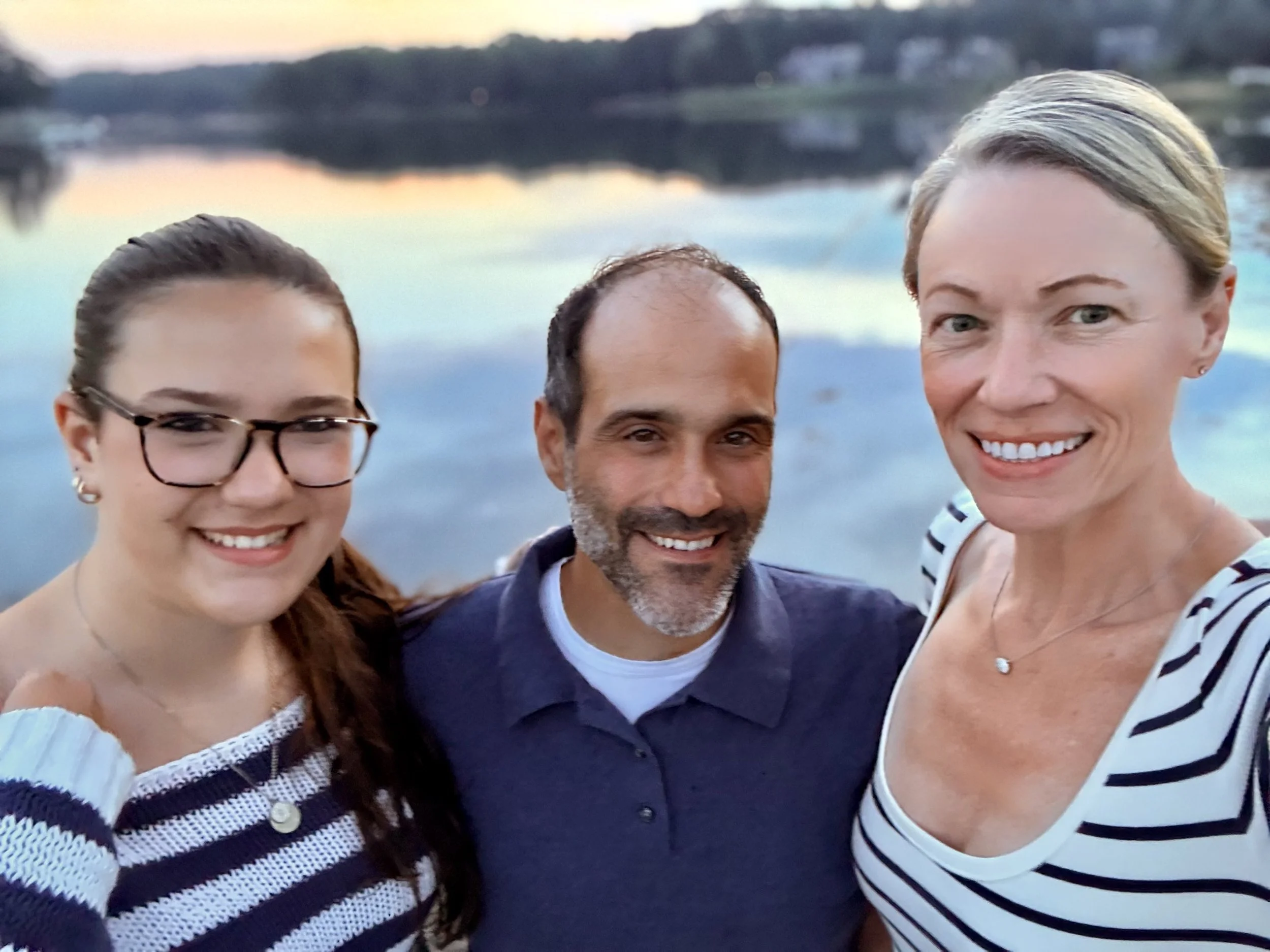 Rachel Krompinger with her husband Jason and daughter Maddy at sunset near the water