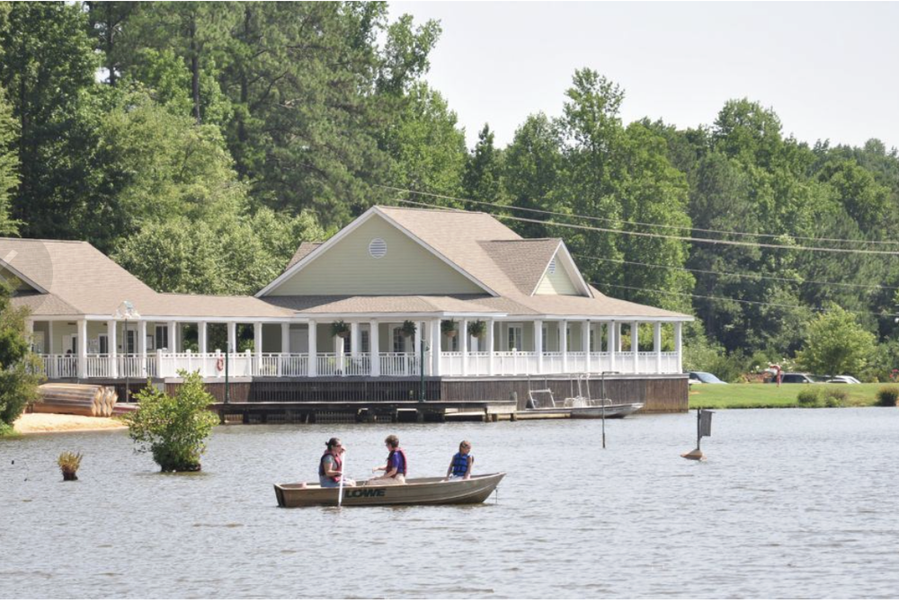 Visitors boating on Bass Lake beside the park building