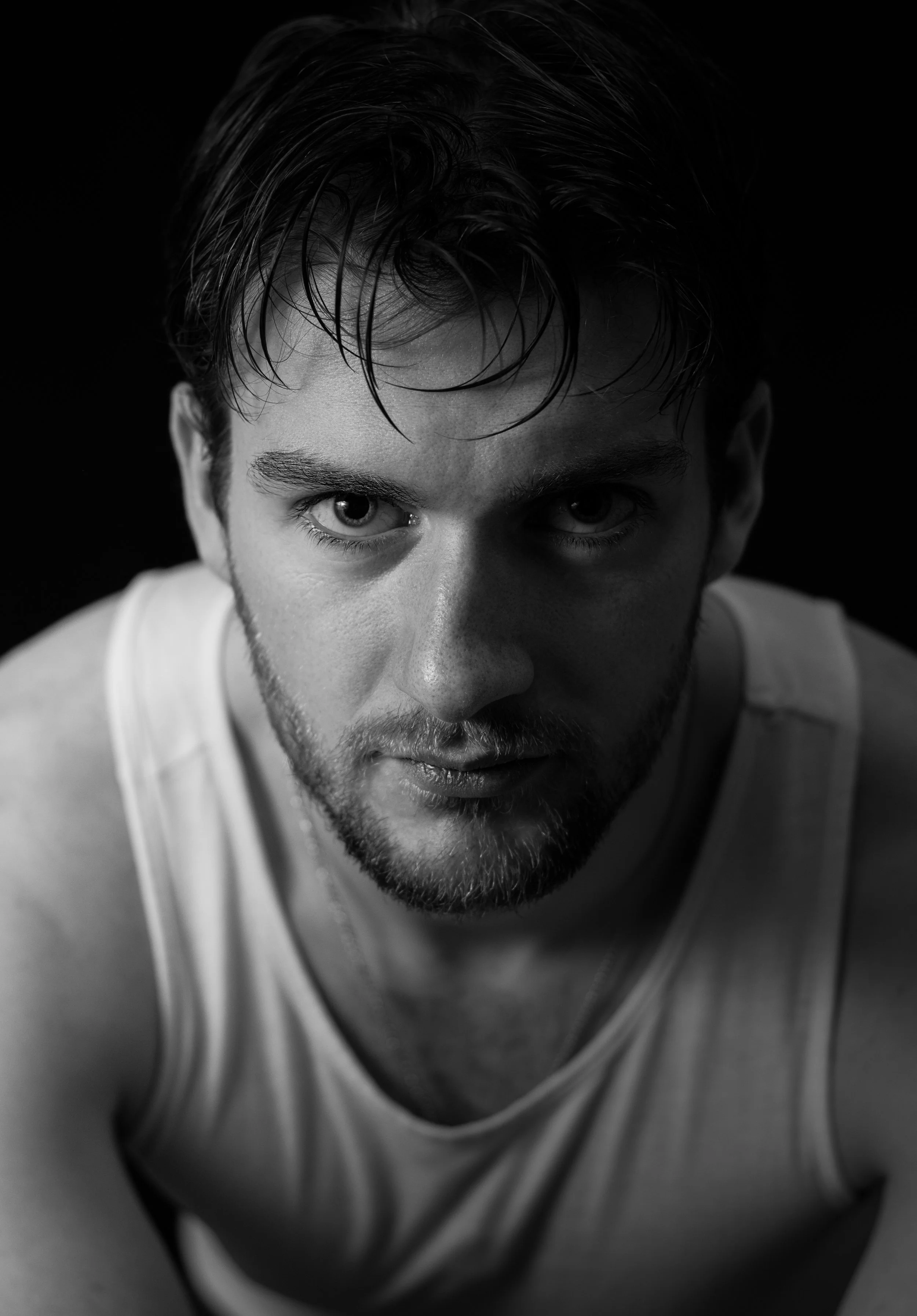 A close-up black and white photo of a young man, Lyall Hardy Grey, with wet hair, looking directly at the camera.