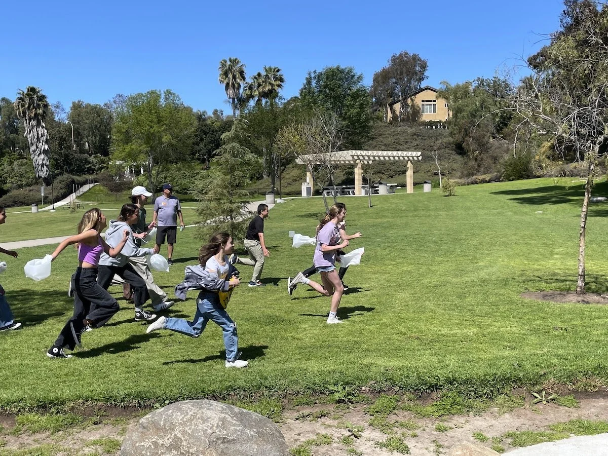 Group of children and teenagers running outdoors in a park on a sunny day