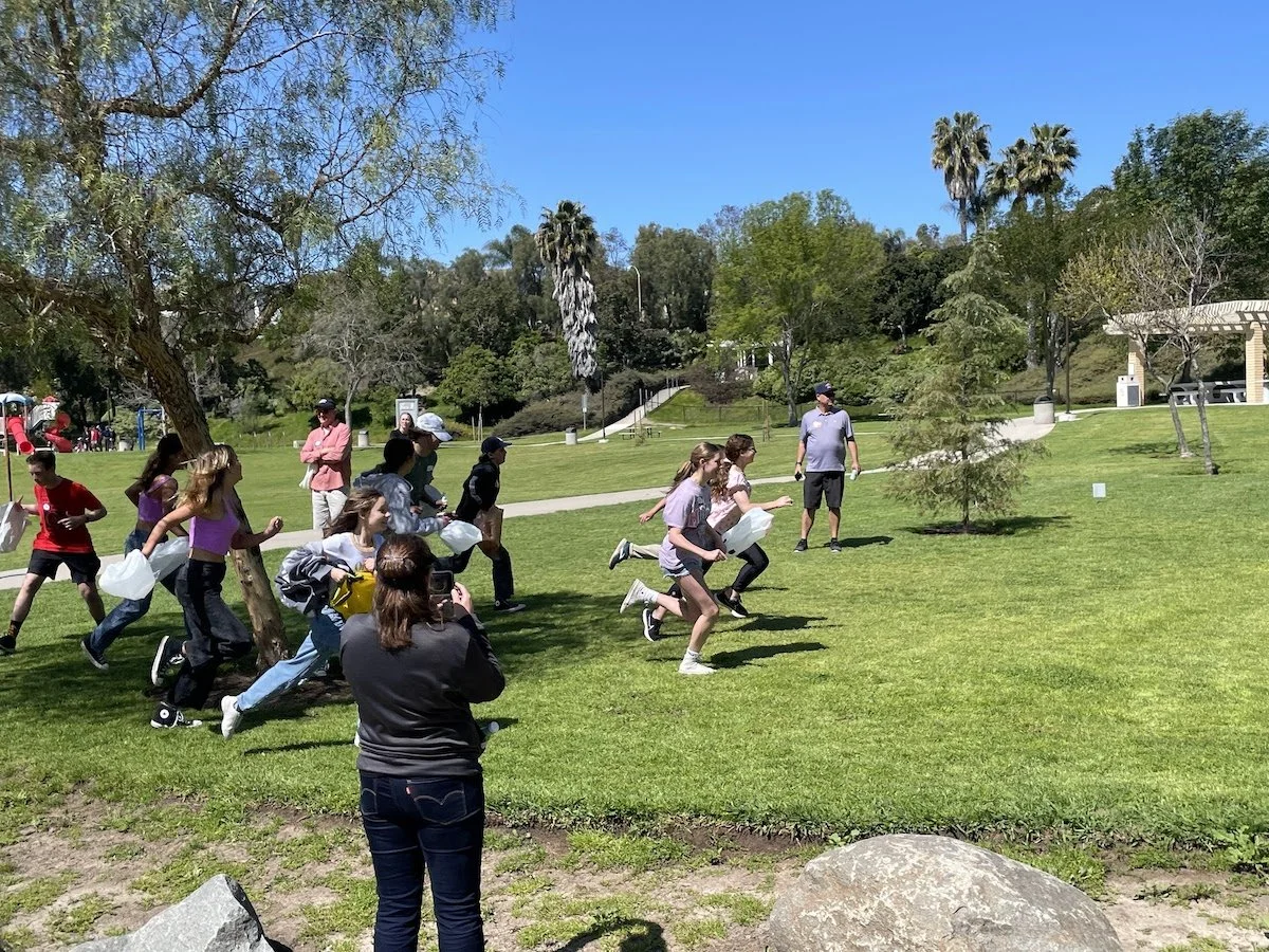 Group of children running outdoors in a park on a sunny day.