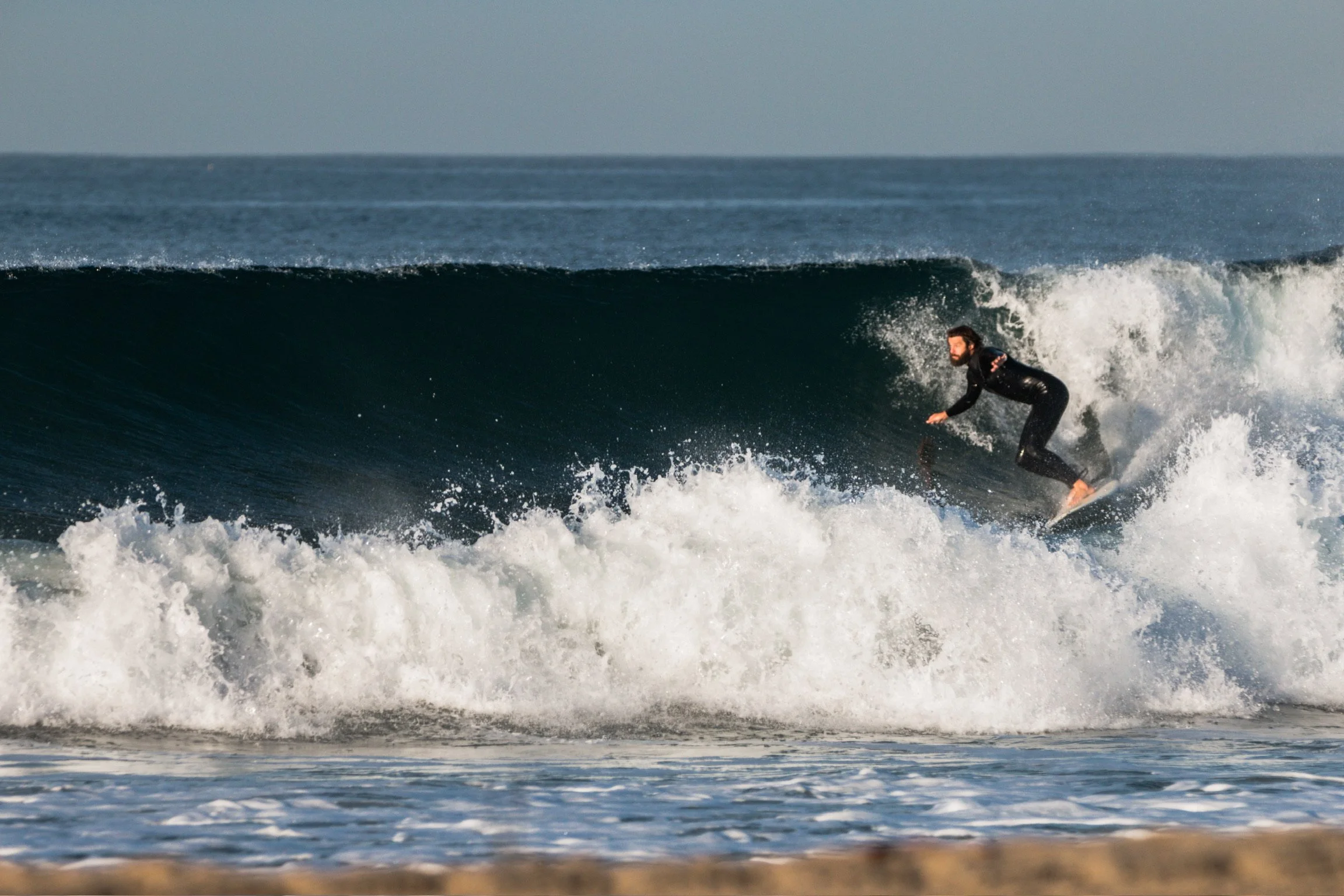 A person surfing on a wave in the ocean.